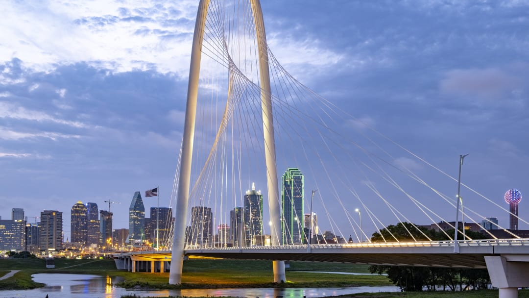 View of the Margaret Hunt Hill Bridge with the Dallas skyline in the background.