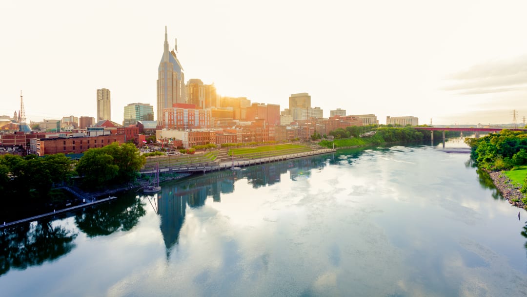 View of Nashville's skyline with the Cumberland river in the foreground.
