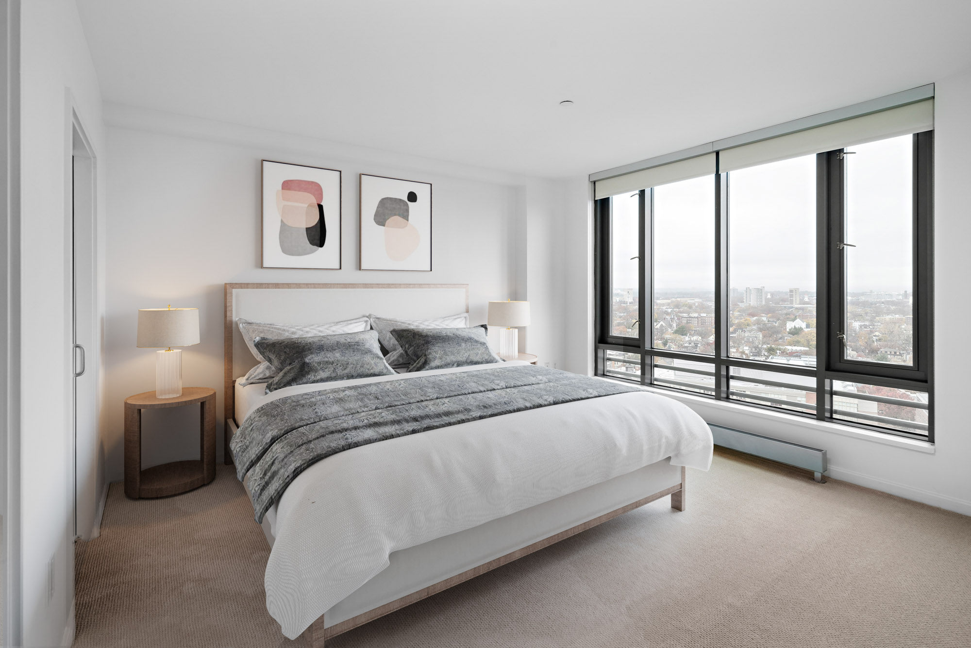 Bedroom with windows overlooking the city at 100 Landsdowne St apartments