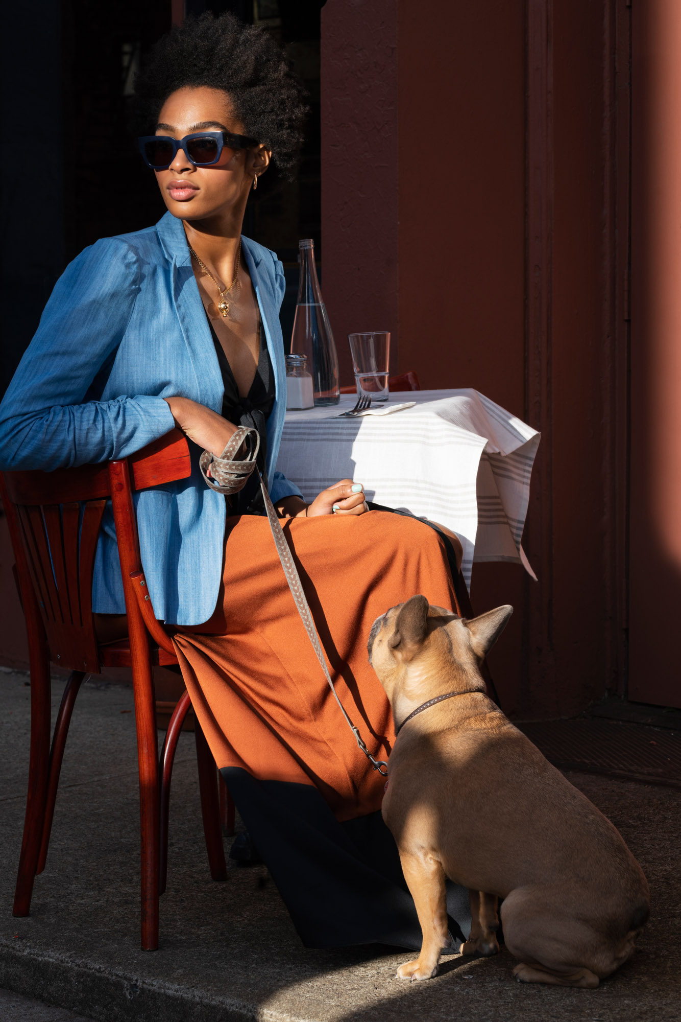 A woman dining with her dog near Two Blue Slip apartments.