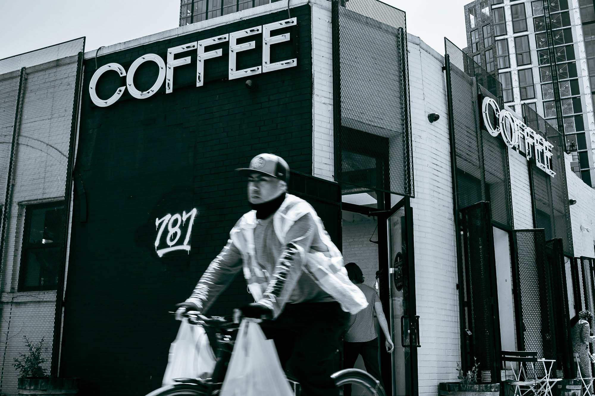 A person bikes in front of a coffee shop near Lincoln at Bankside in the Bronx, NY.