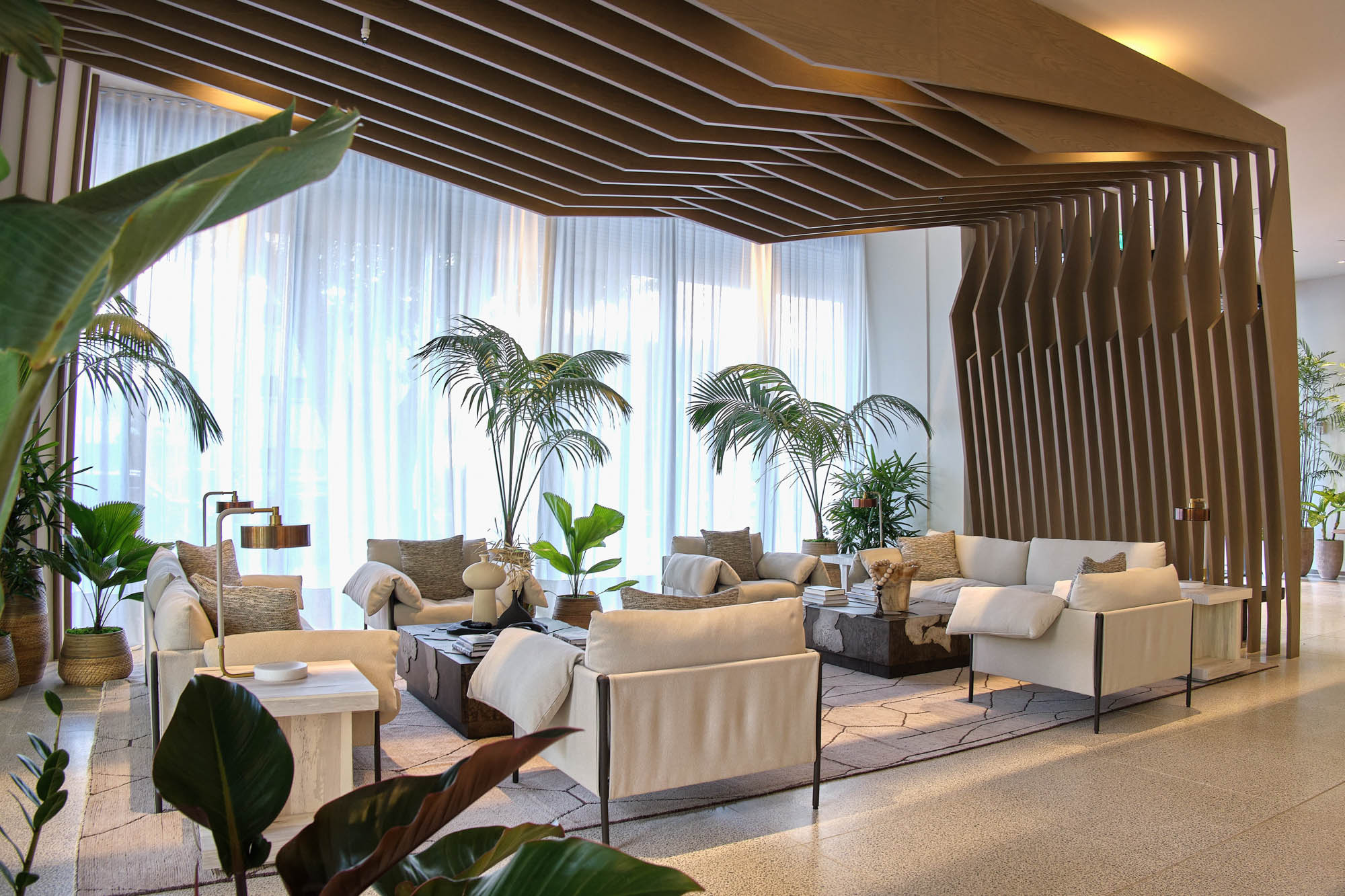 An inviting modern lobby with plush seating, surrounded by palms.