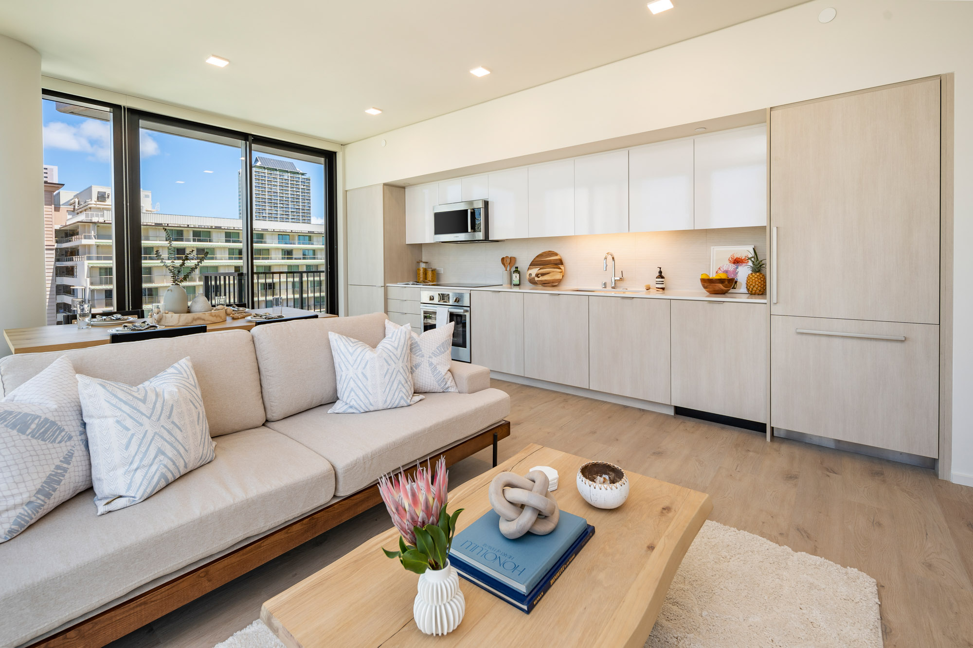 Galley kitchen and living area near floor-to-ceiling windows.