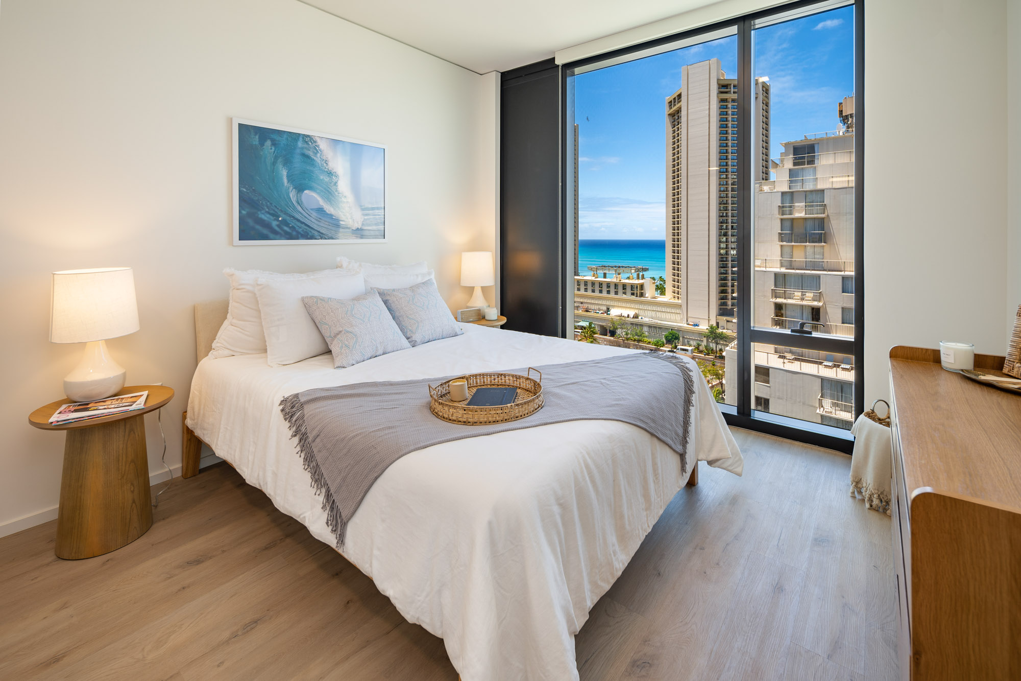 Bedroom with floor-to-ceiling windows and a view of the ocean.