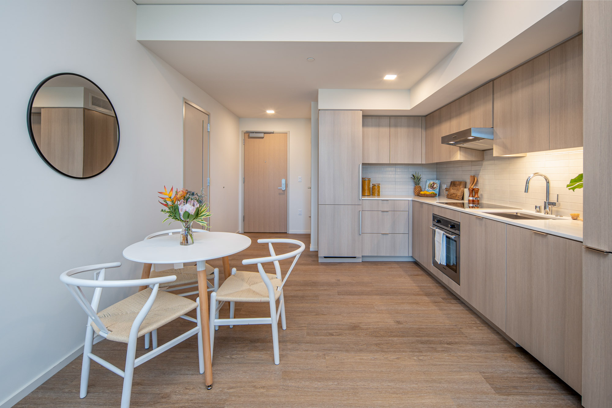 Modern kitchen with panelized appliances and dining area.