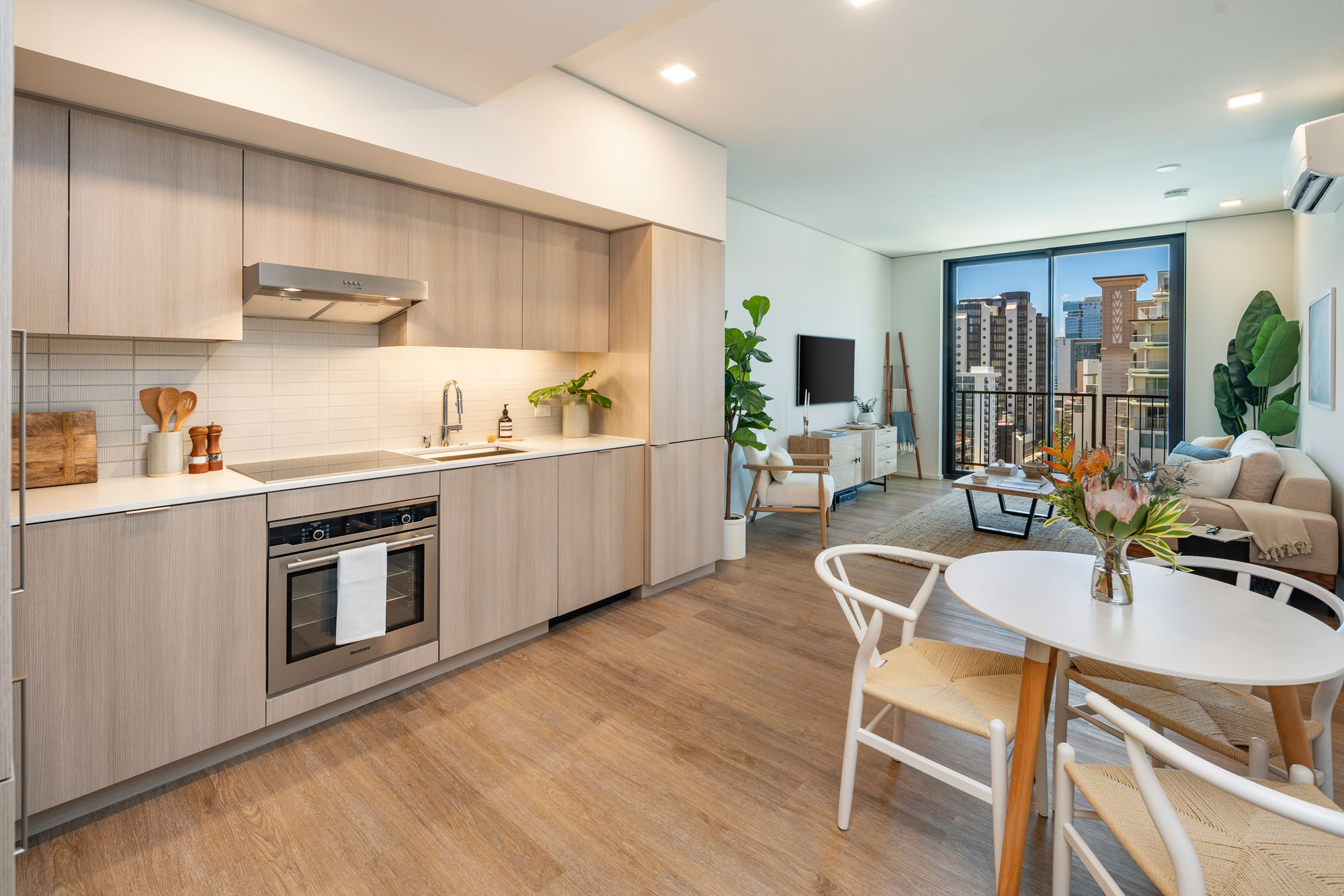 Open-concept kitchen, dining, and living area with floor-to-ceiling windows.