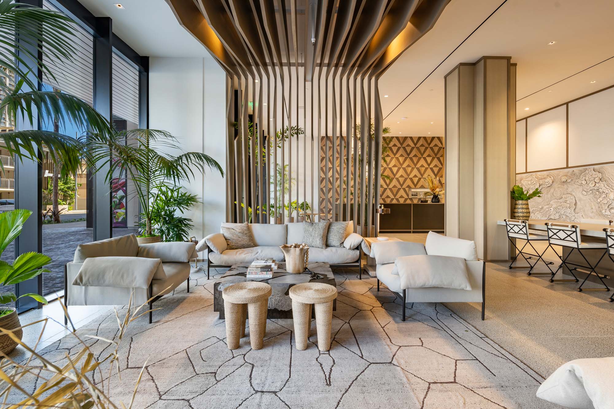 Modern lobby with plush seating and palm trees.