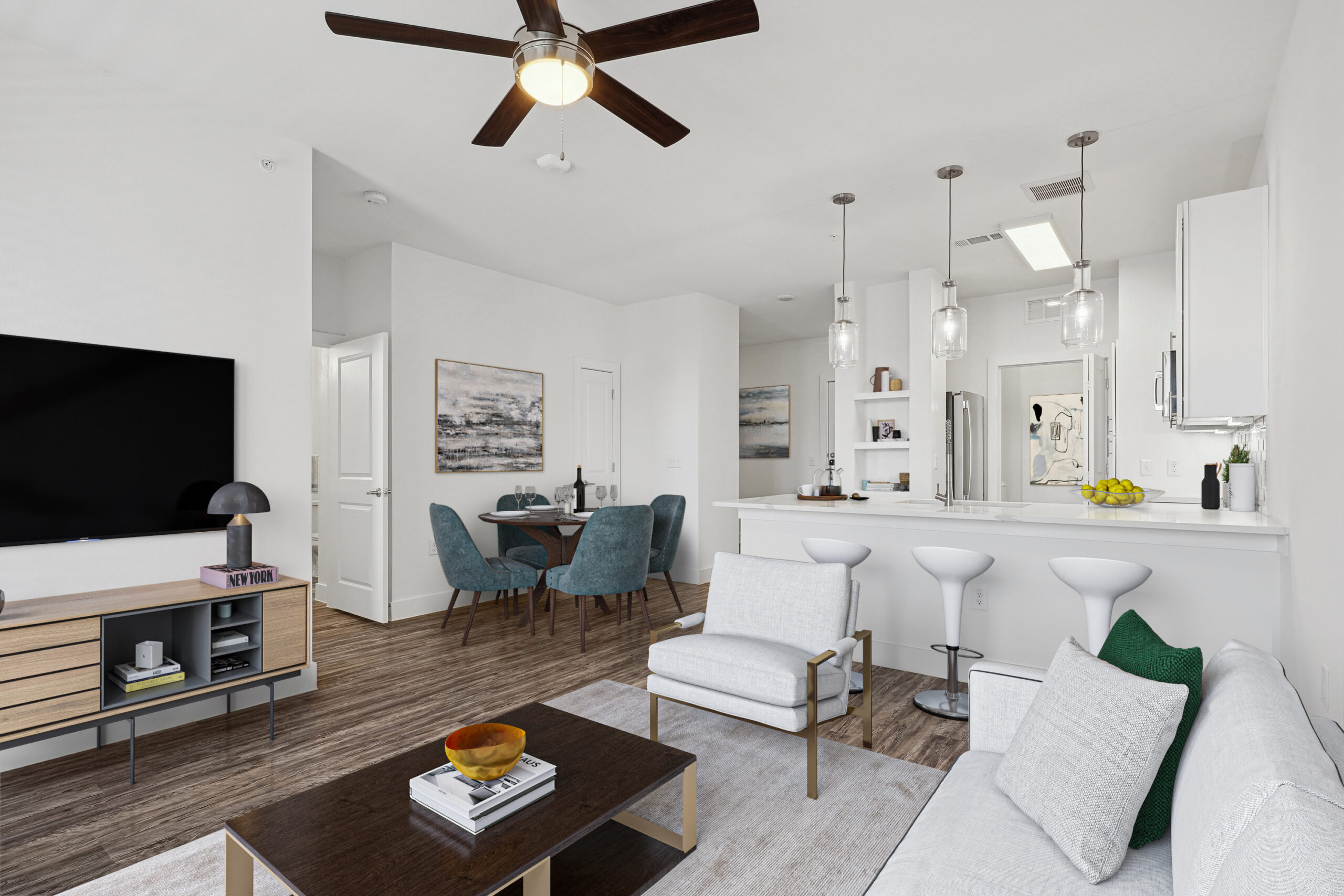Open-concept living and dining area in apartments in Garland Texas featuring modern finishes, wood-style floors, and a bright kitchen with pendant lighting