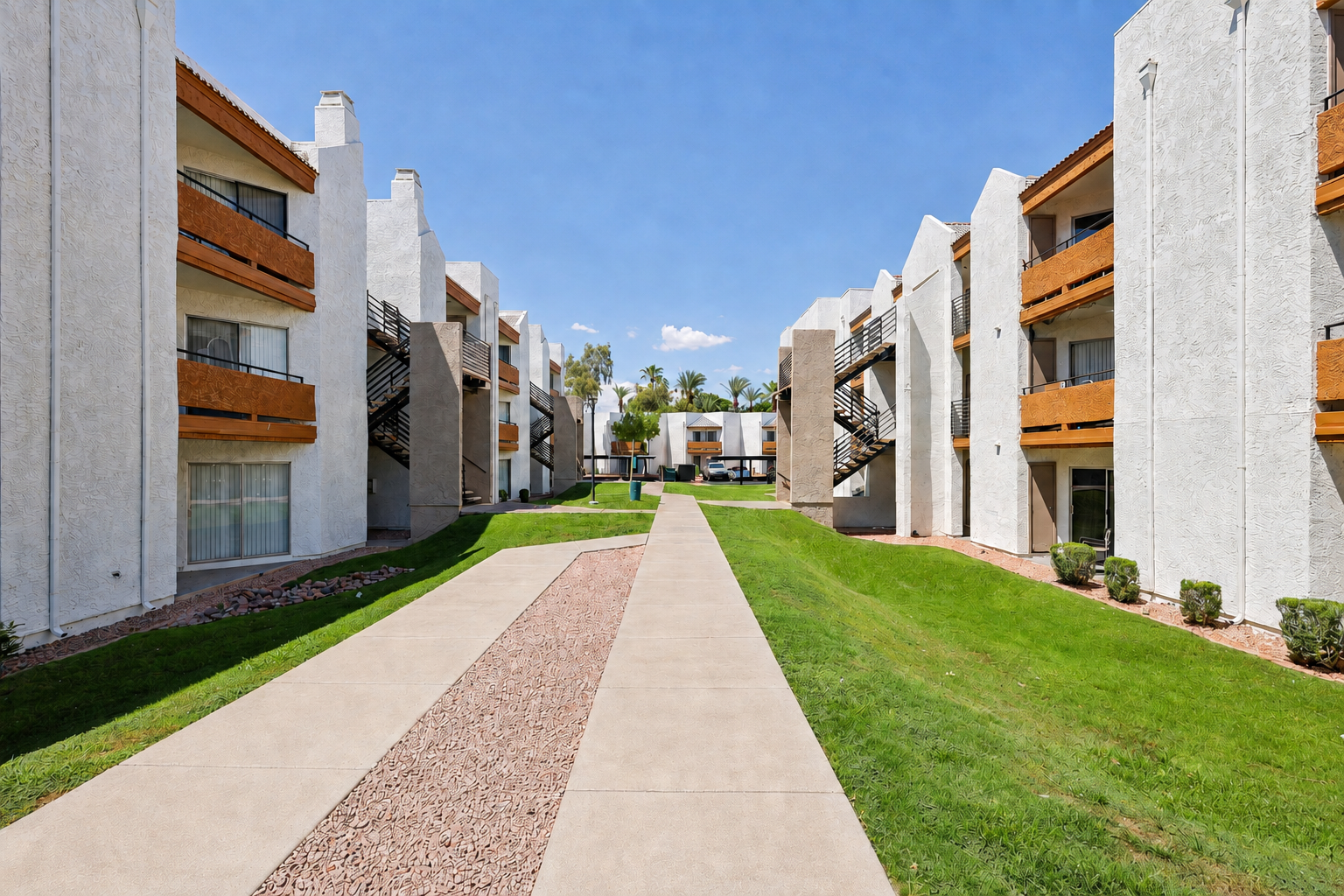 Clean courtyard walkways between apartment buildings with green lawns, exterior stairways, and orange balcony accents.