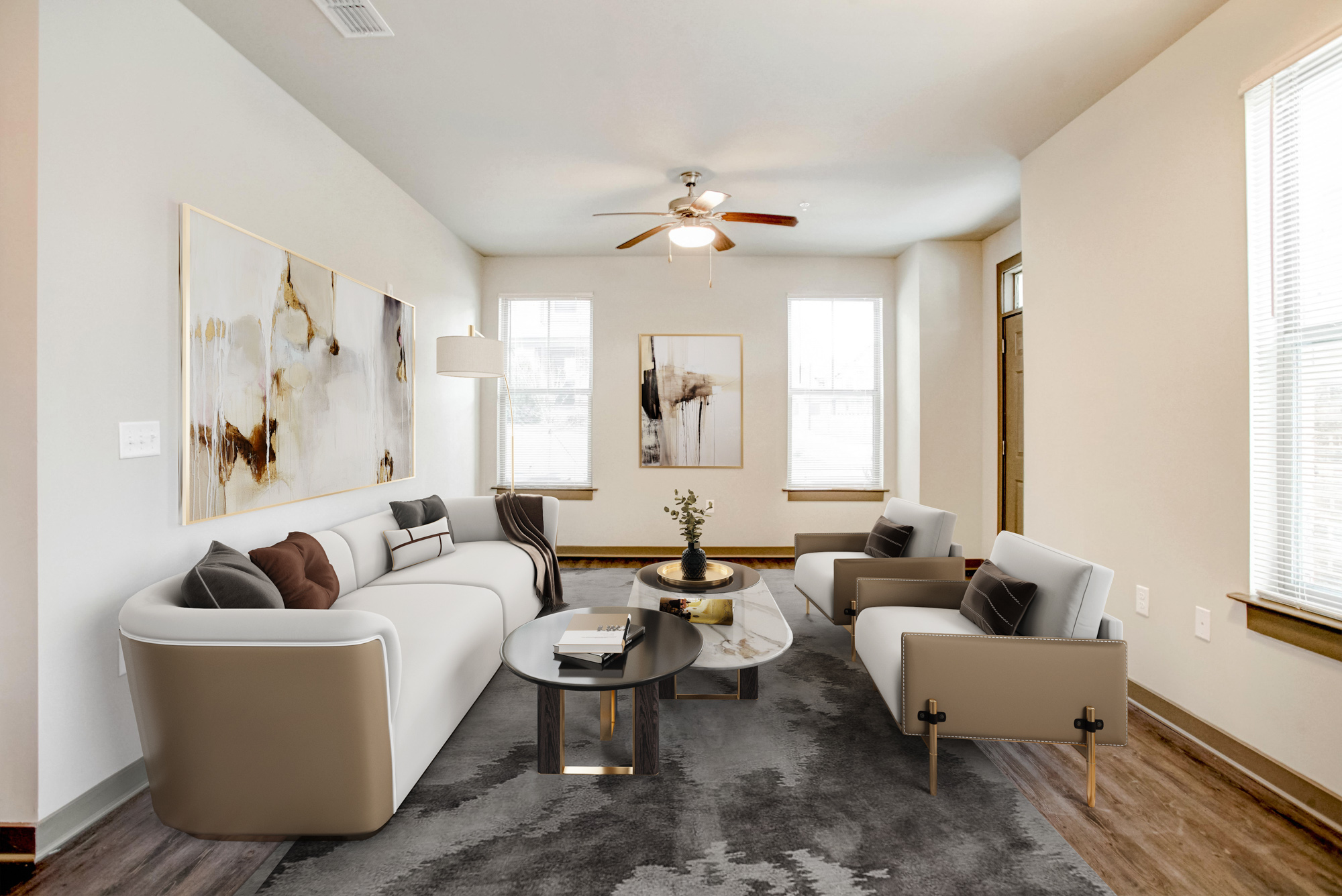 A white couch and chairs with tan sides sit surrounding two coffee tables.