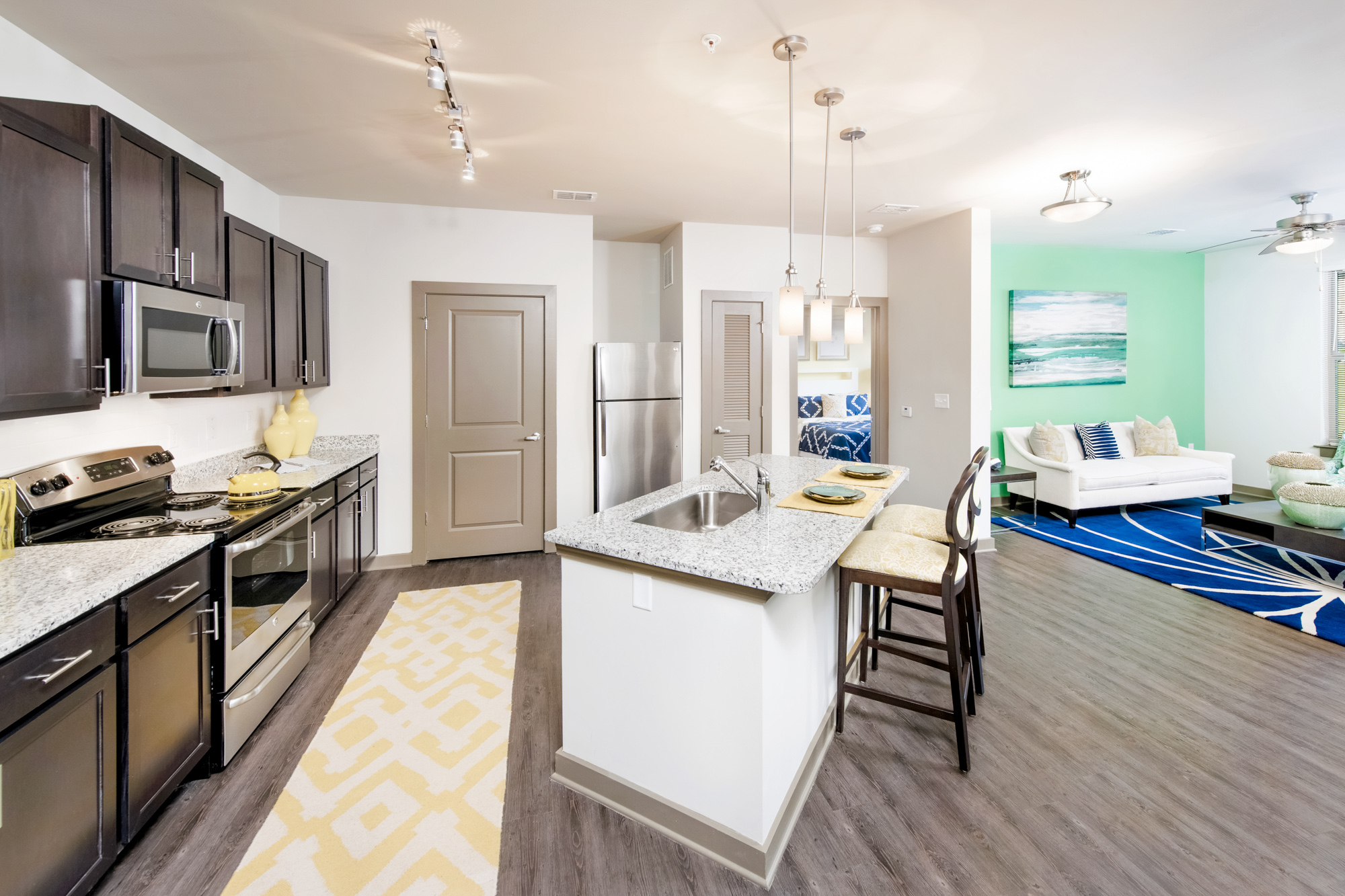 A fully-equipped kitchen is on the left and a living area is on the right.