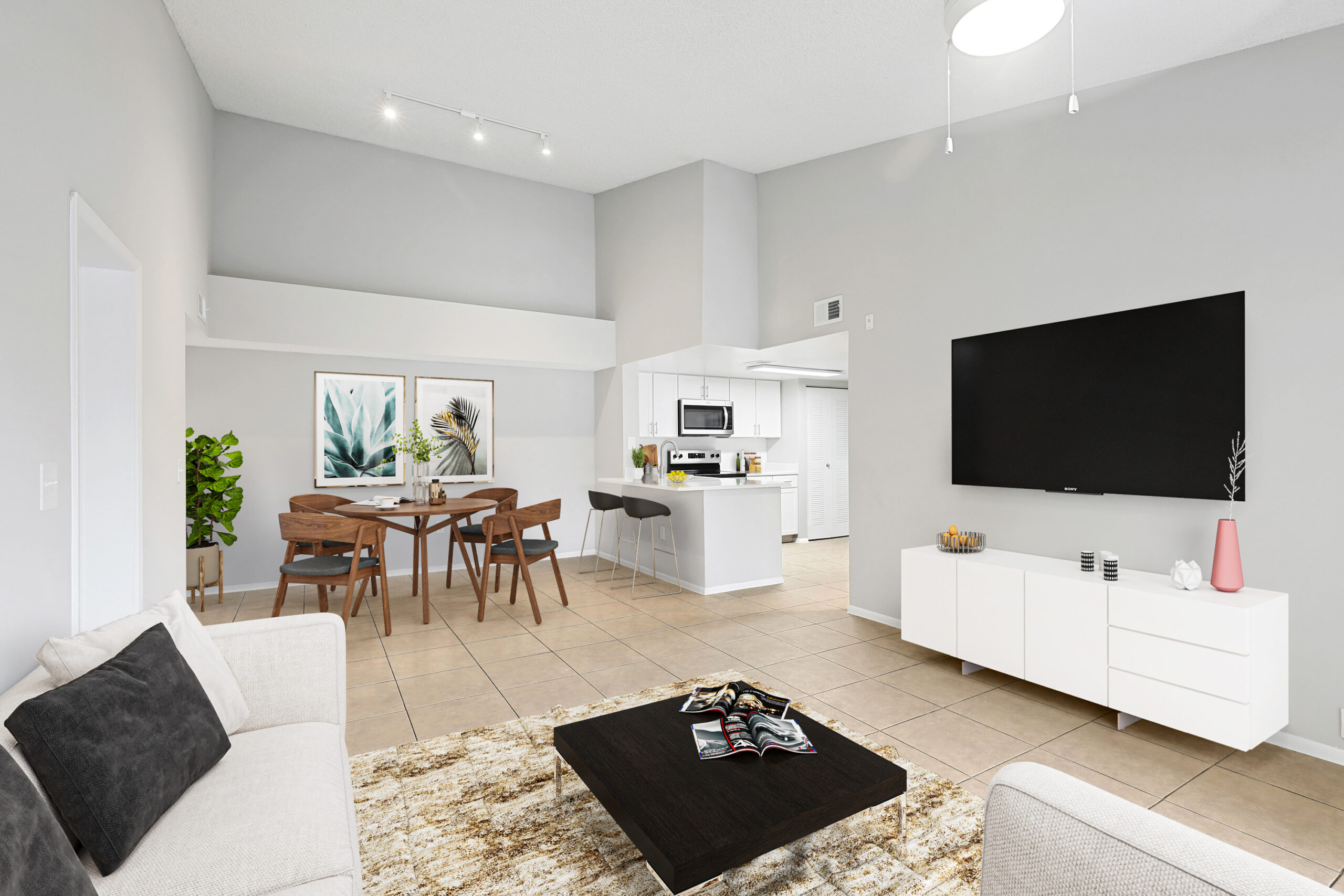 Living/Dining/Kitchen area is an open concept with plenty of room for a dining table for four, bar stools at the breakfast bar, and a large sofa, coffee table and tv in the living room