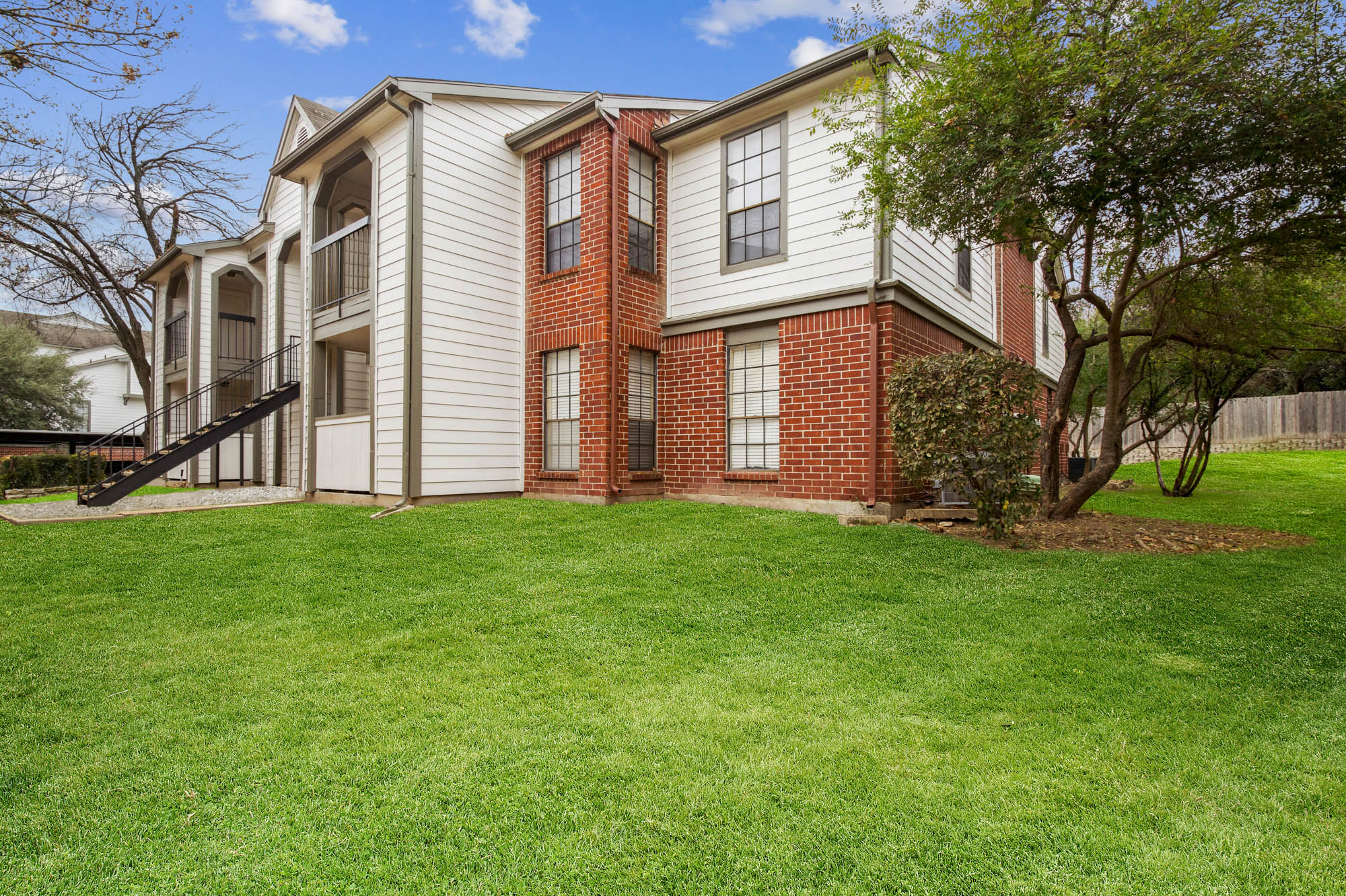 The exterior of an apartment building at The Arbors of Wells Branch in Austin, TX.