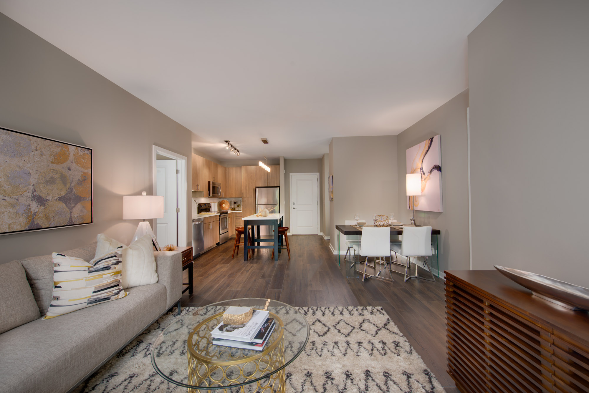 A living room, kitchen, and dining area in The Parker at Huntington Metro apartment in Alexandria, VA.