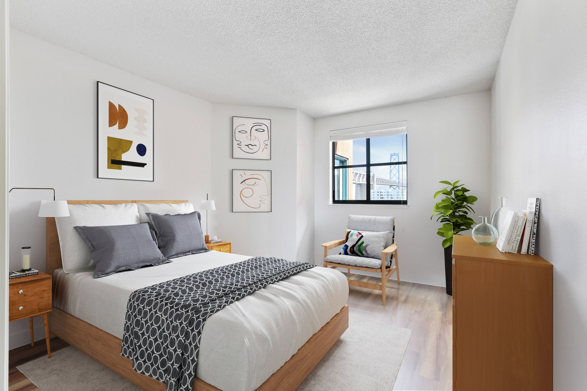A bedroom with hardwood floors ana a window with city views at Bayside Village apartments in San Francisco