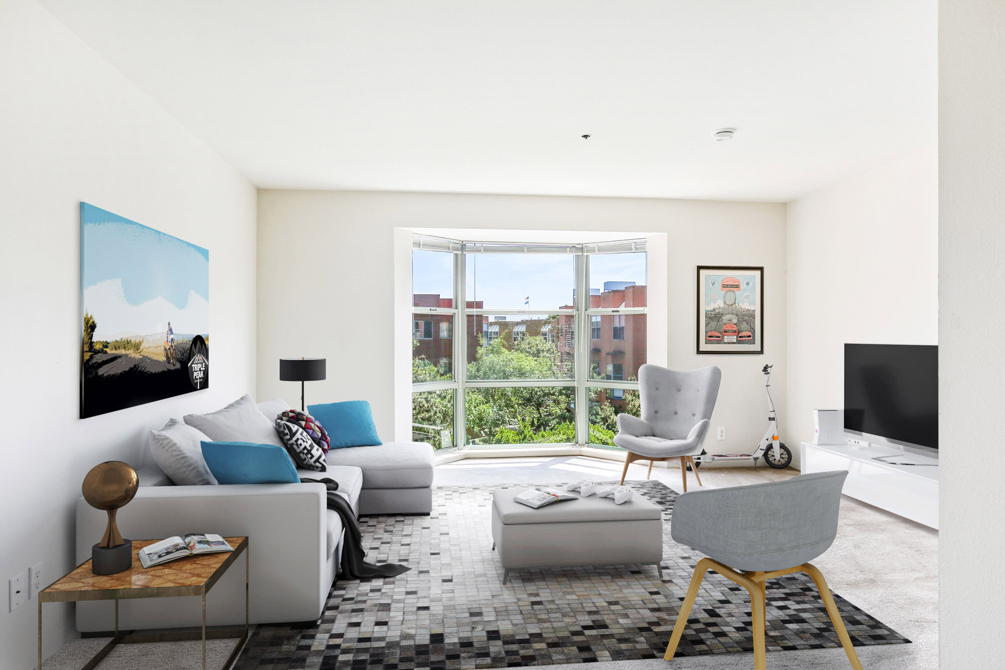 A living room with a large bay window at Bayside Village apartments in downtown San Francisco