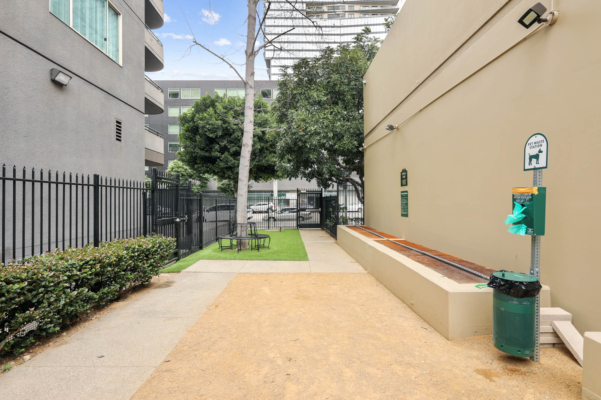 A dog run with a dog bin for waste and benches at The Met apartments in downtown LA