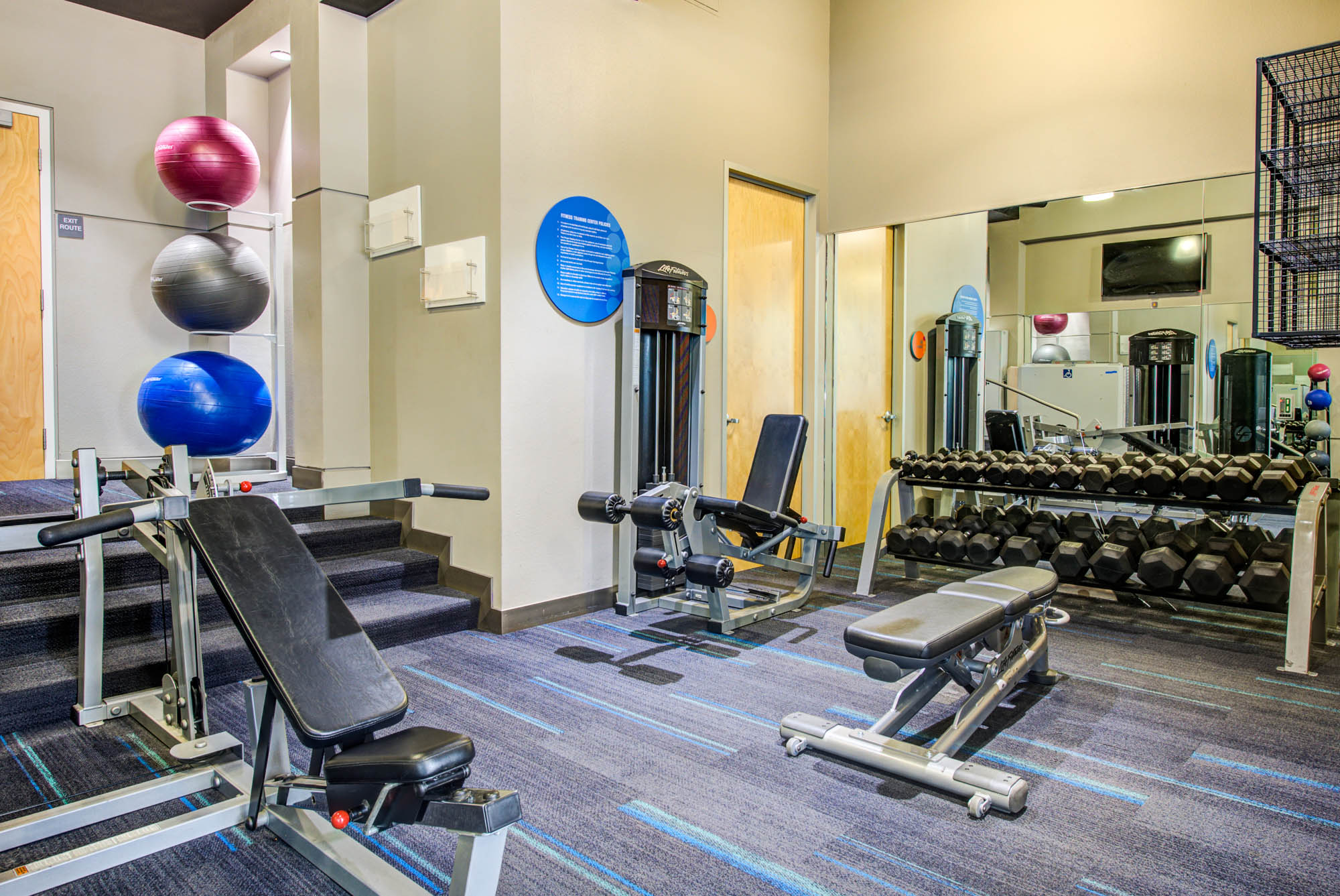 A fitness center with with weights and medicine balls at The Met apartments in downtown LA