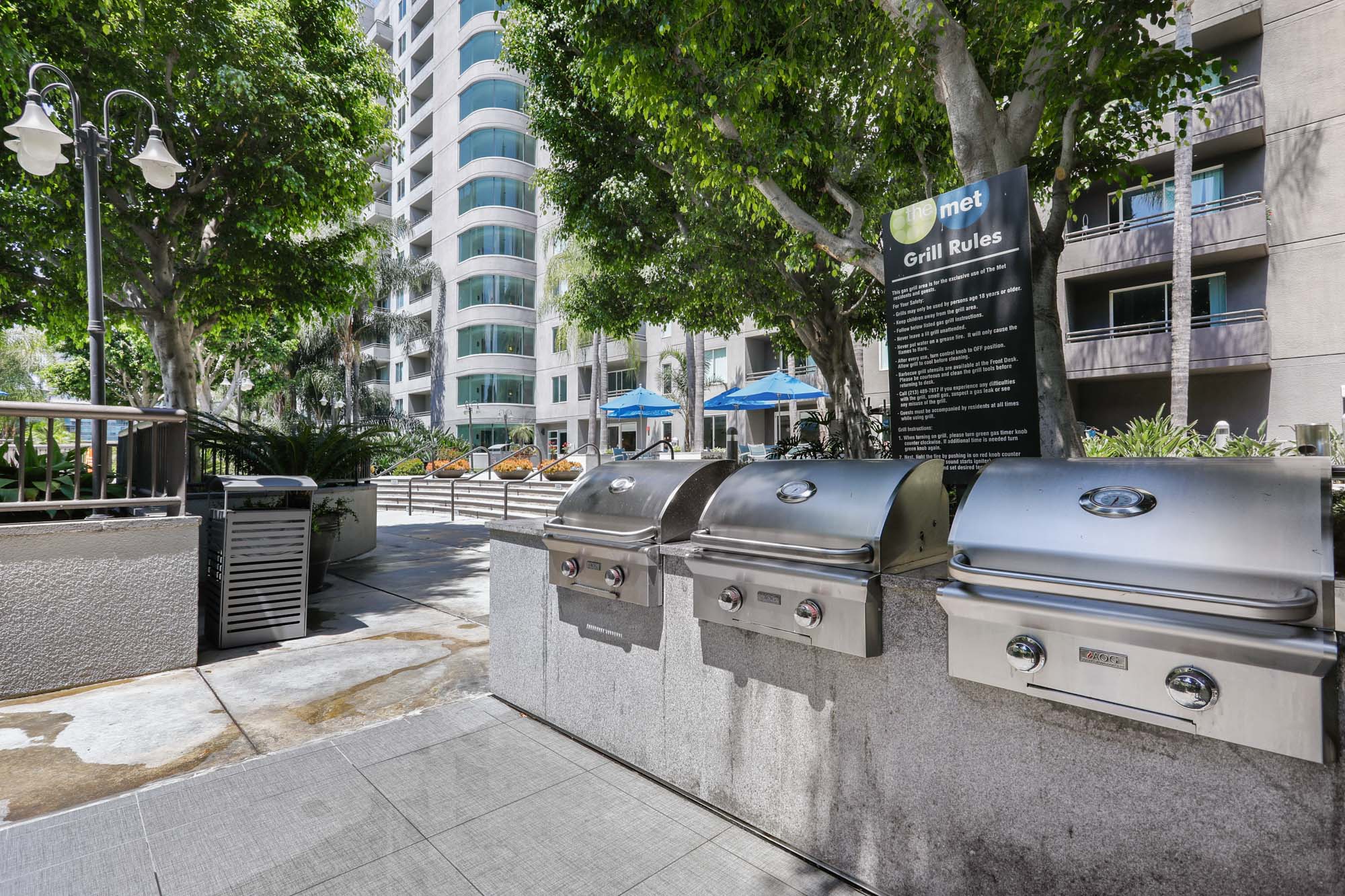 Three outdoor grills next to the pool area at The Met modern apartments in downtown LA