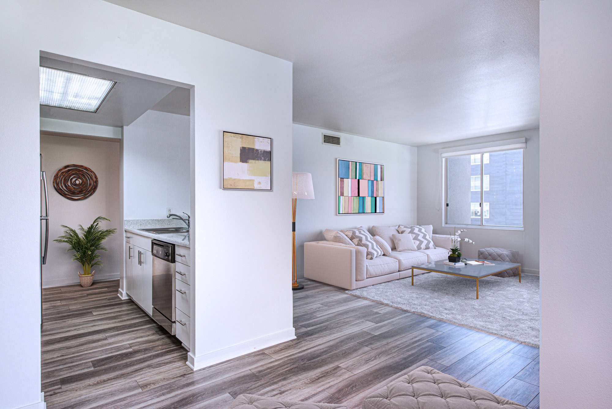 A kitchen space and a living room with hardwood floors at The Met's South Park downtown la apartments