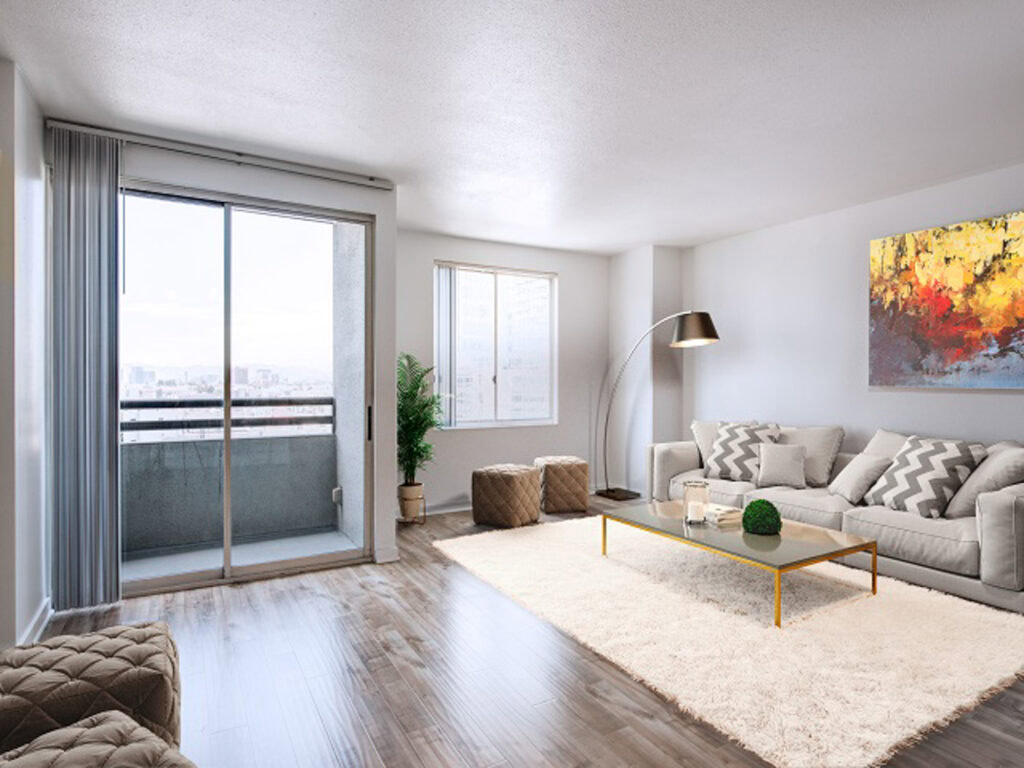 A living room with hard wood floors, and a glass door leading to a balcony The Mets modern apartments in downtown LA