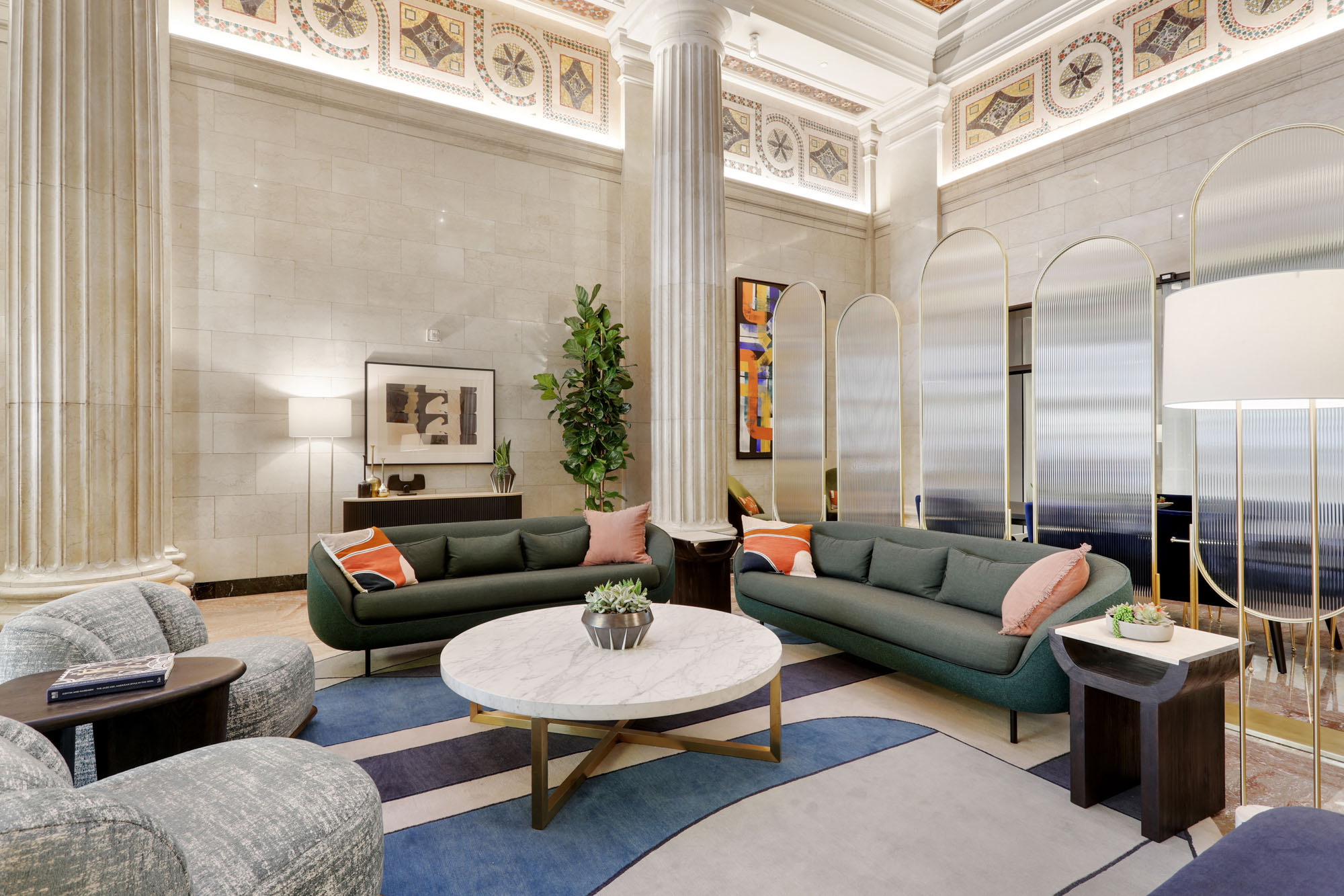 A Beaux arts themed lobby lounge with arched glass panels at Metro 417's modern apartments in DTLA