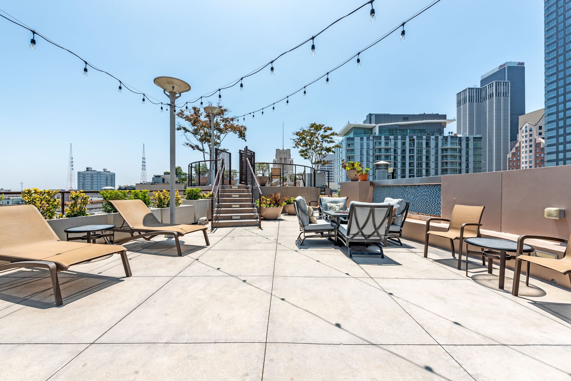 A rooftop lounge with seating areas, lounging chairs with city views at Metro 417 in downtown LA
