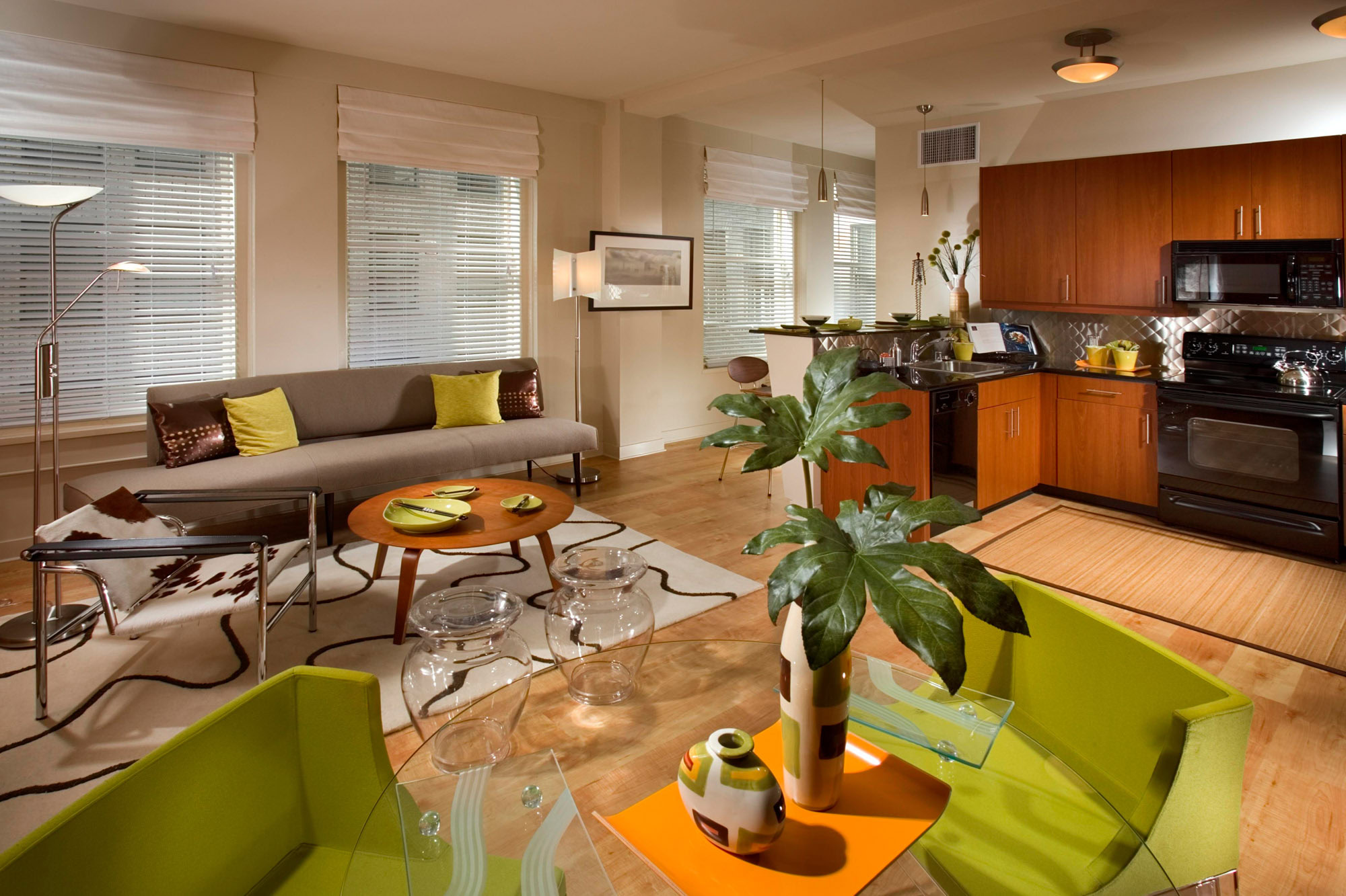 An open plan living room and L shaped kitchen with with four large windows at a Metro 417 apartment in downtown LA