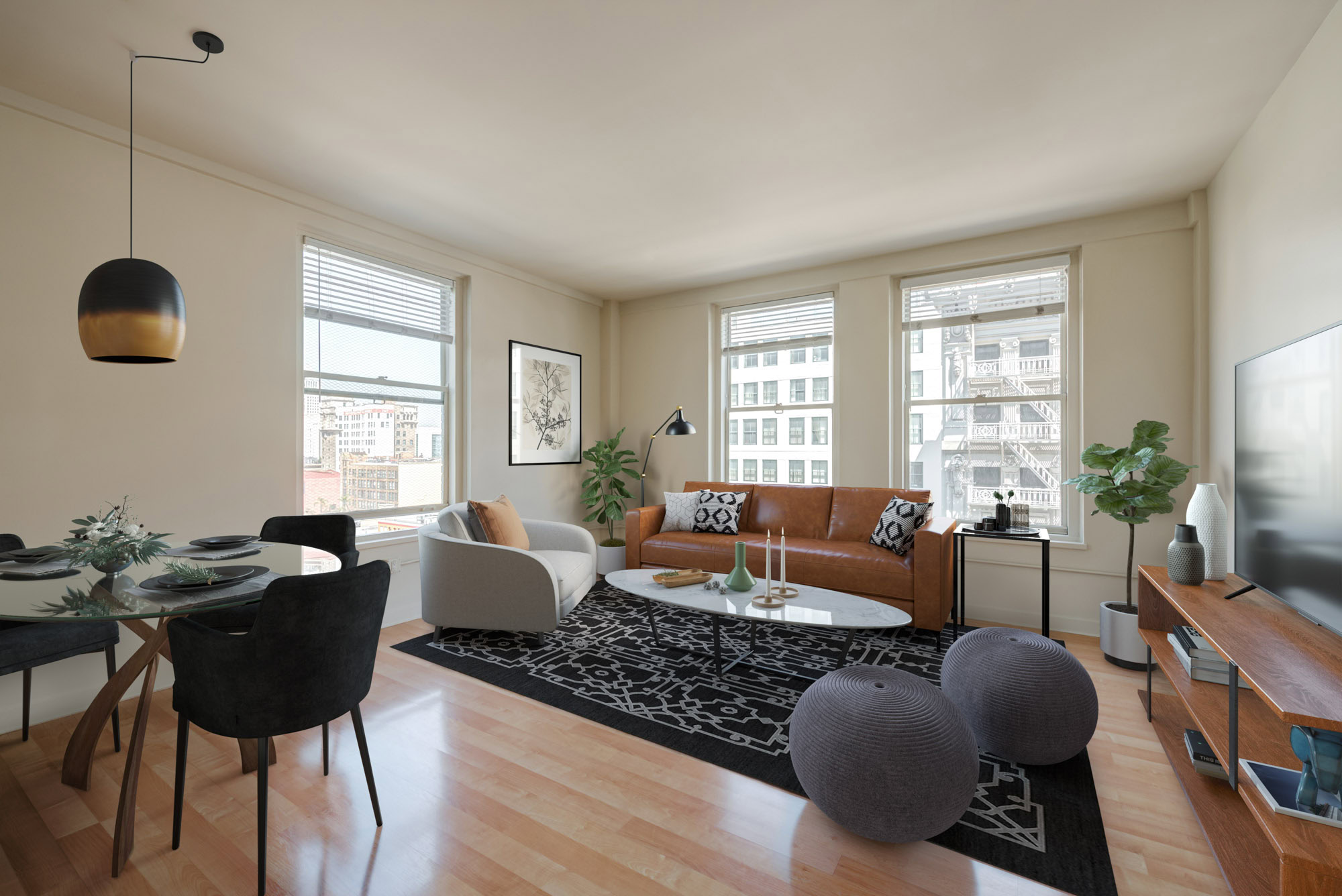 A living room area with three large windows bringing in natural lighting at Metro 417's modern apartments in downtown LA