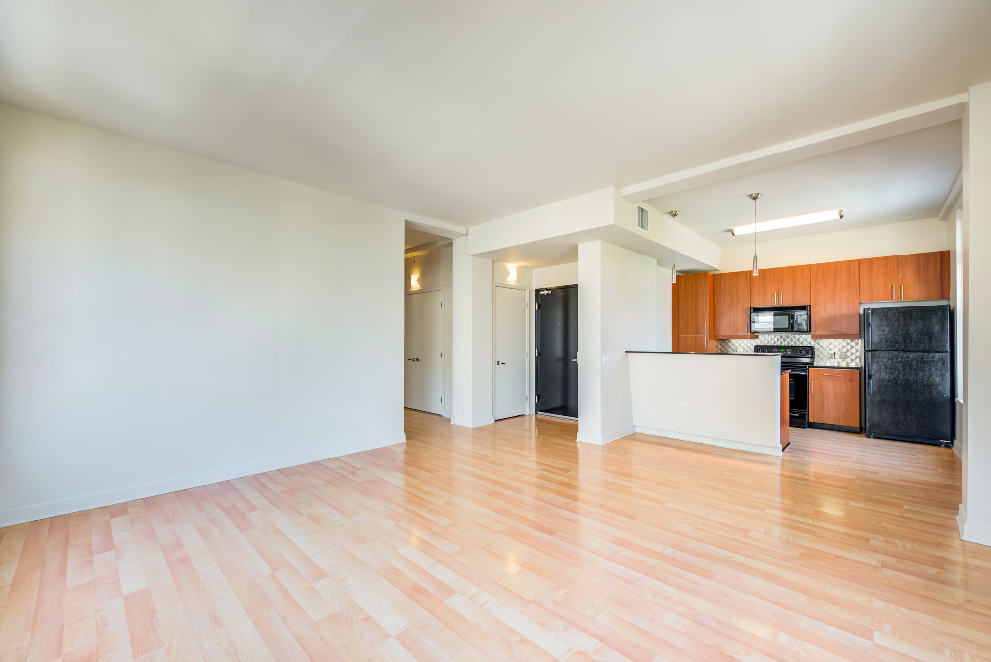 A spacious apartment with a kitchen, peninsula island and hardwood floors at Metro 417's downtown LA apartments