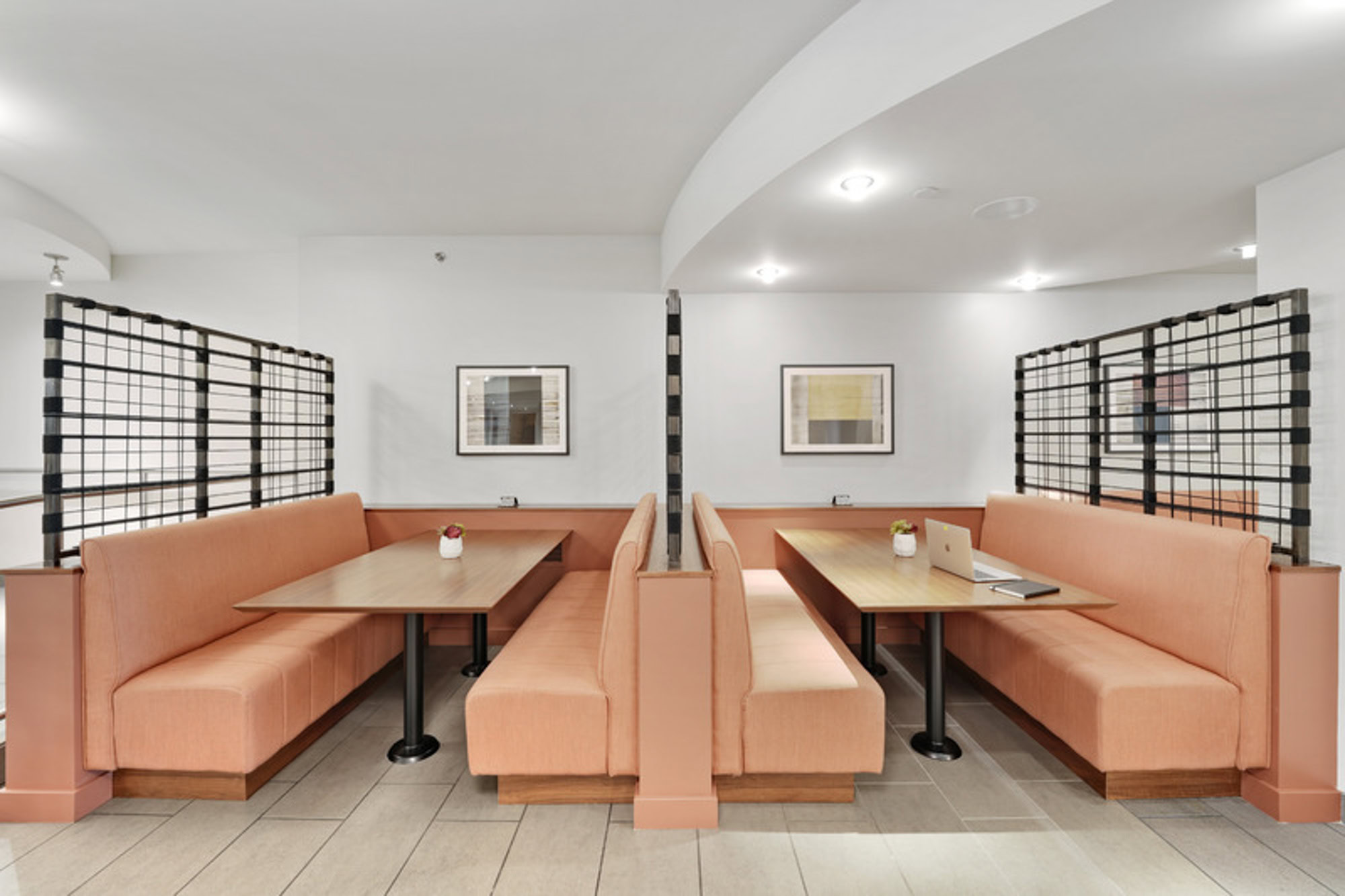 A community lounge with peach colored booth seating for work and dining at the Mosso apartments in San Francisco 