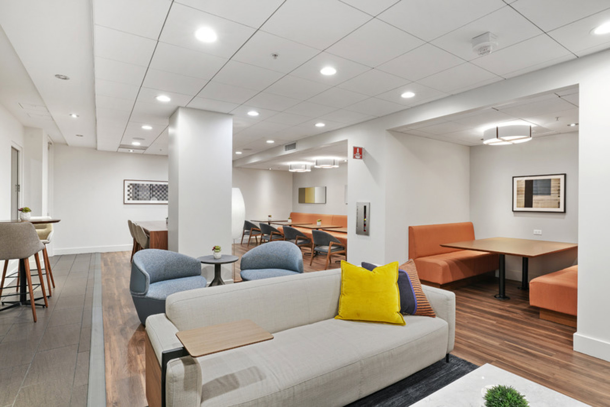 A community lounge with several seating areas and tables at the Mosso luxury apartments in San Francisco