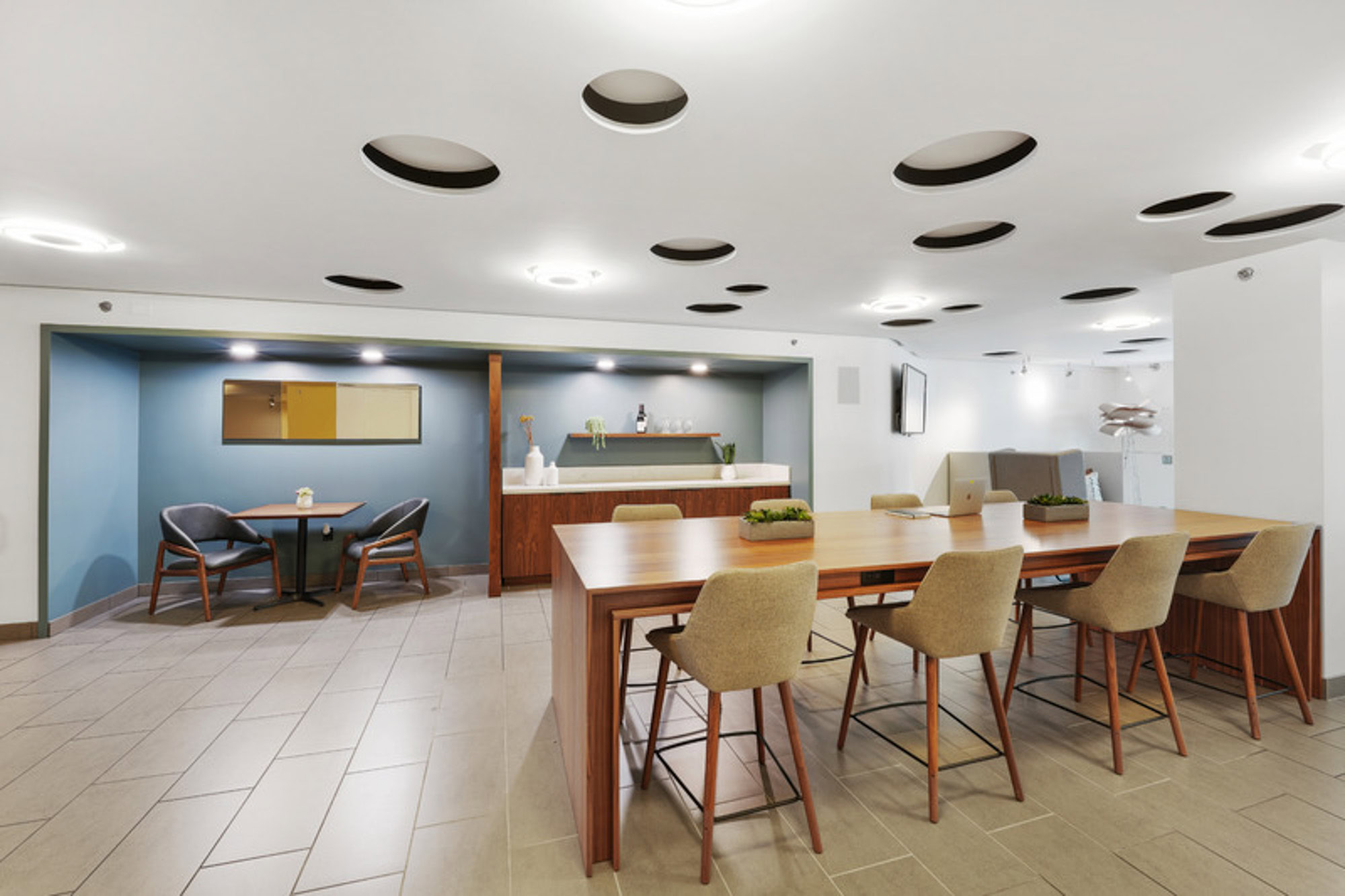 A community work space with large and small tables for work at the Mosso apartments in downtown San Francisco