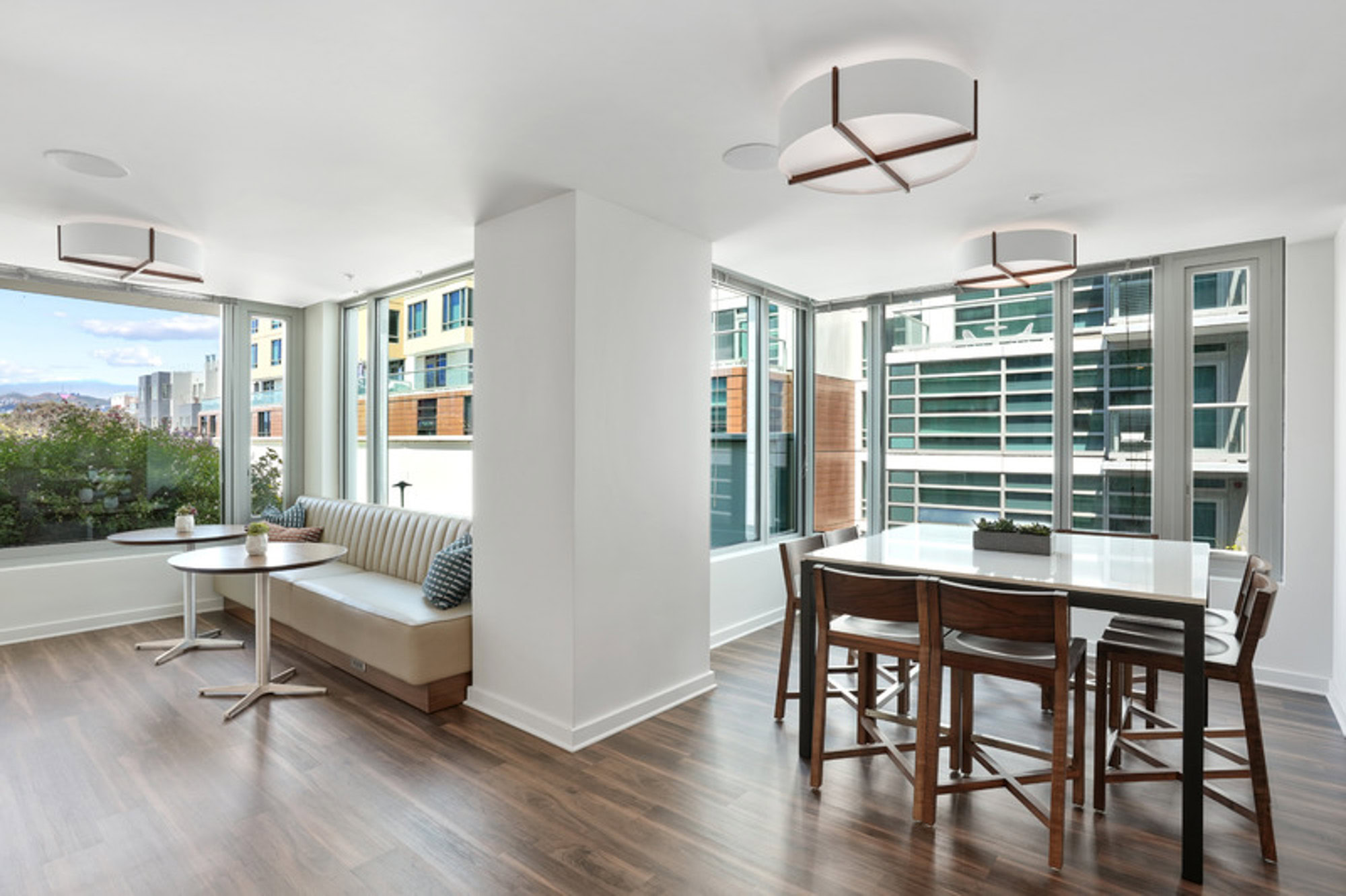 A coworking lounge with windows looking out to the city at Mosso apartments in downtown San Francisco