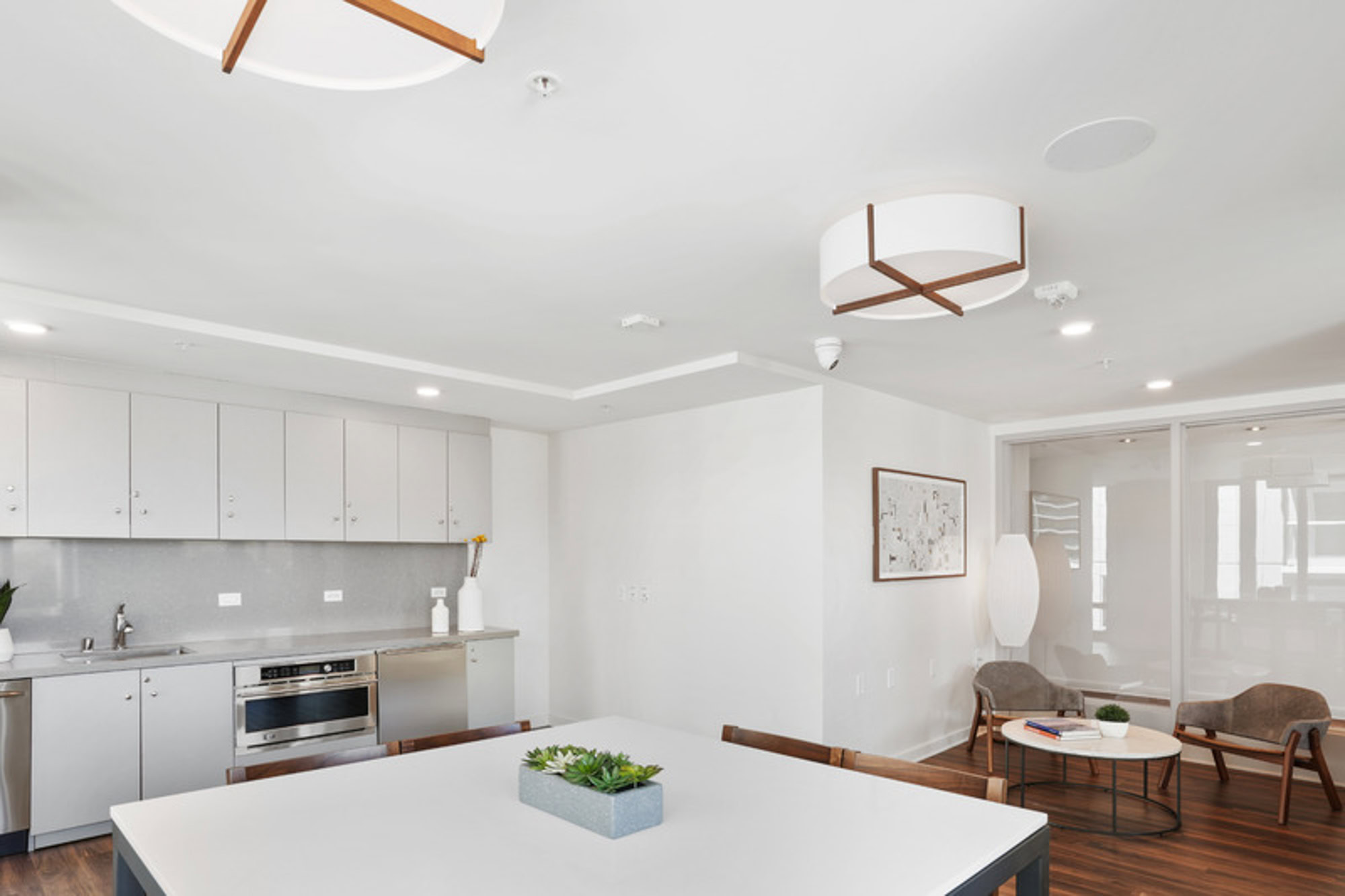 A luxury lounge, with a kitchen and dining area at the Mosso apartments in downtown San Francisco