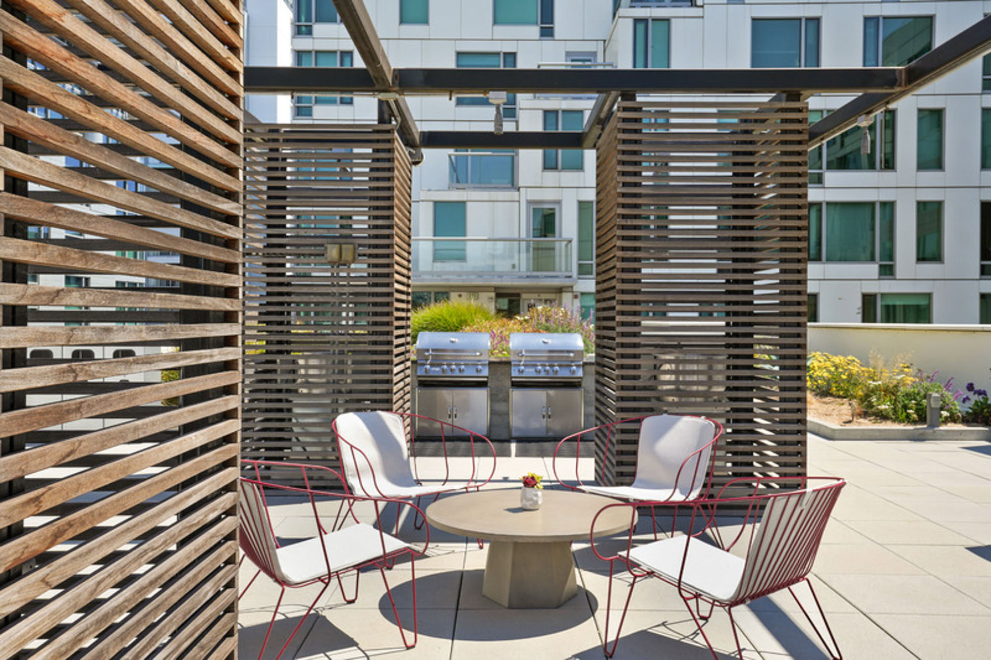 A dining table with panel pillars by the outdoor grills at the Mosso luxury apartments in San Francisco