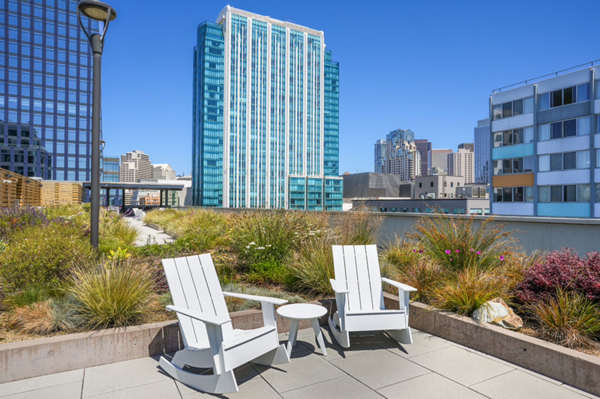A rooftop terrace with a garden and outdoor chairs with city views at Mosso apartments in San Francisco