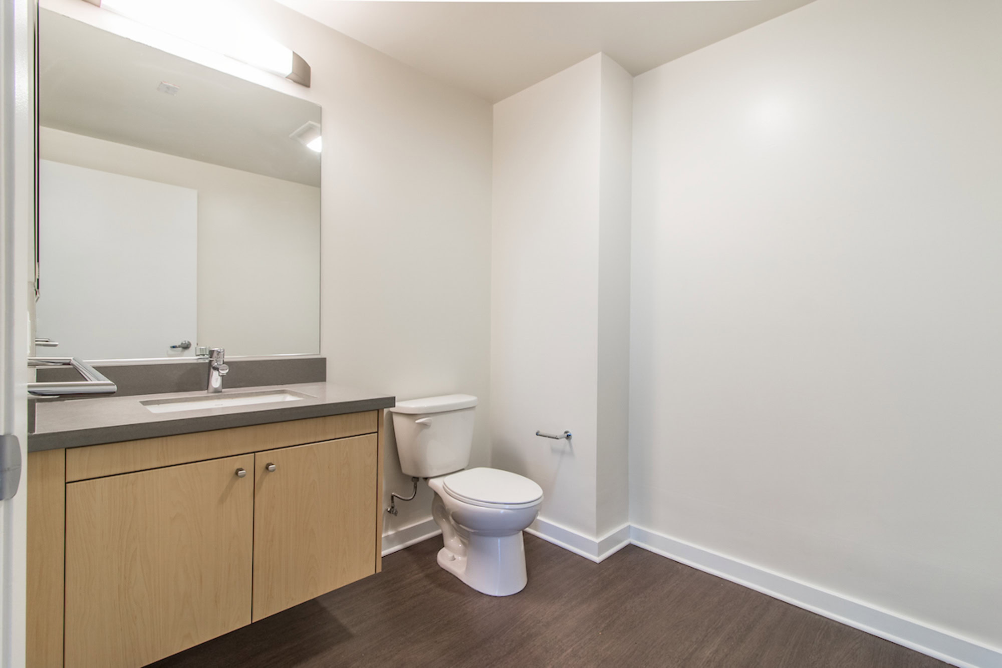 A spacious bathroom with a large mirror over the sink at Mosso apartments in San Francisco