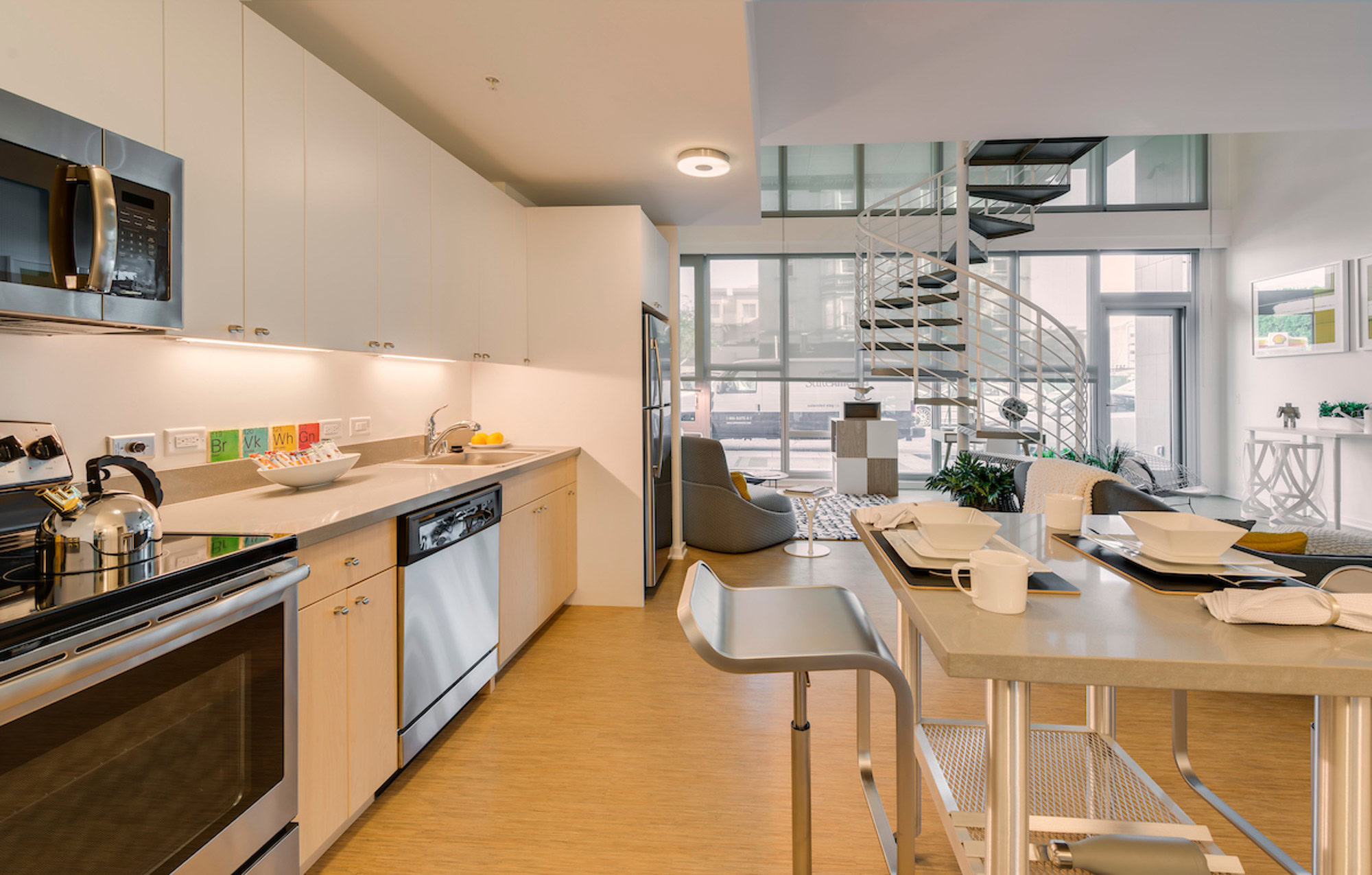 A dining area and kitchen in a Mosso apartment with a spiral staircase in downtown San Francisco's luxury apartments