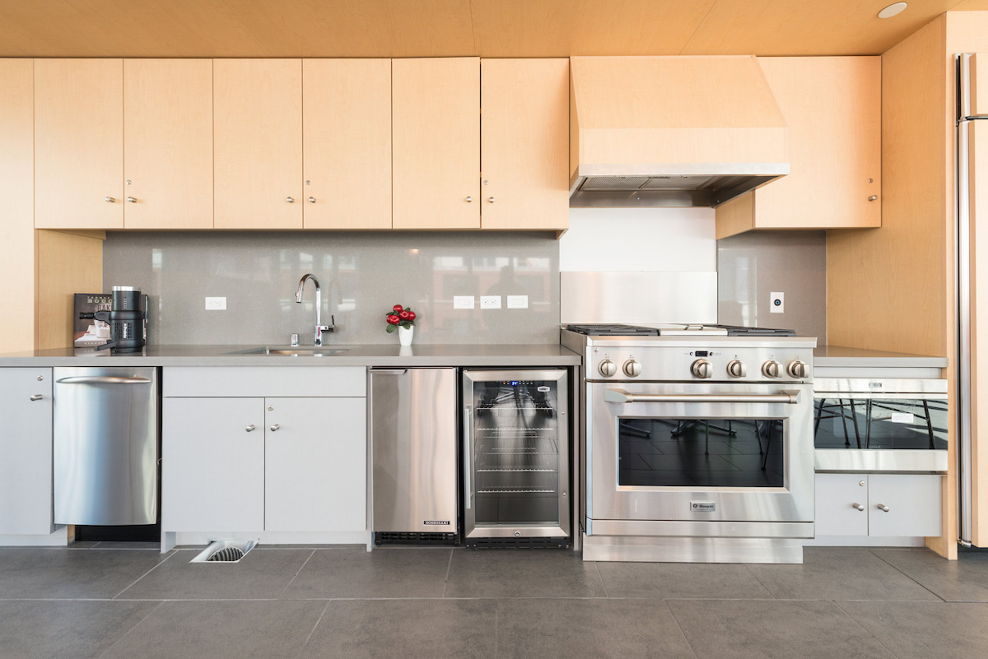 A fully equipped kitchen with stainless steel wine fridge, dishwasher and a gas stove top stove at Mosso apartments in San Francisco
