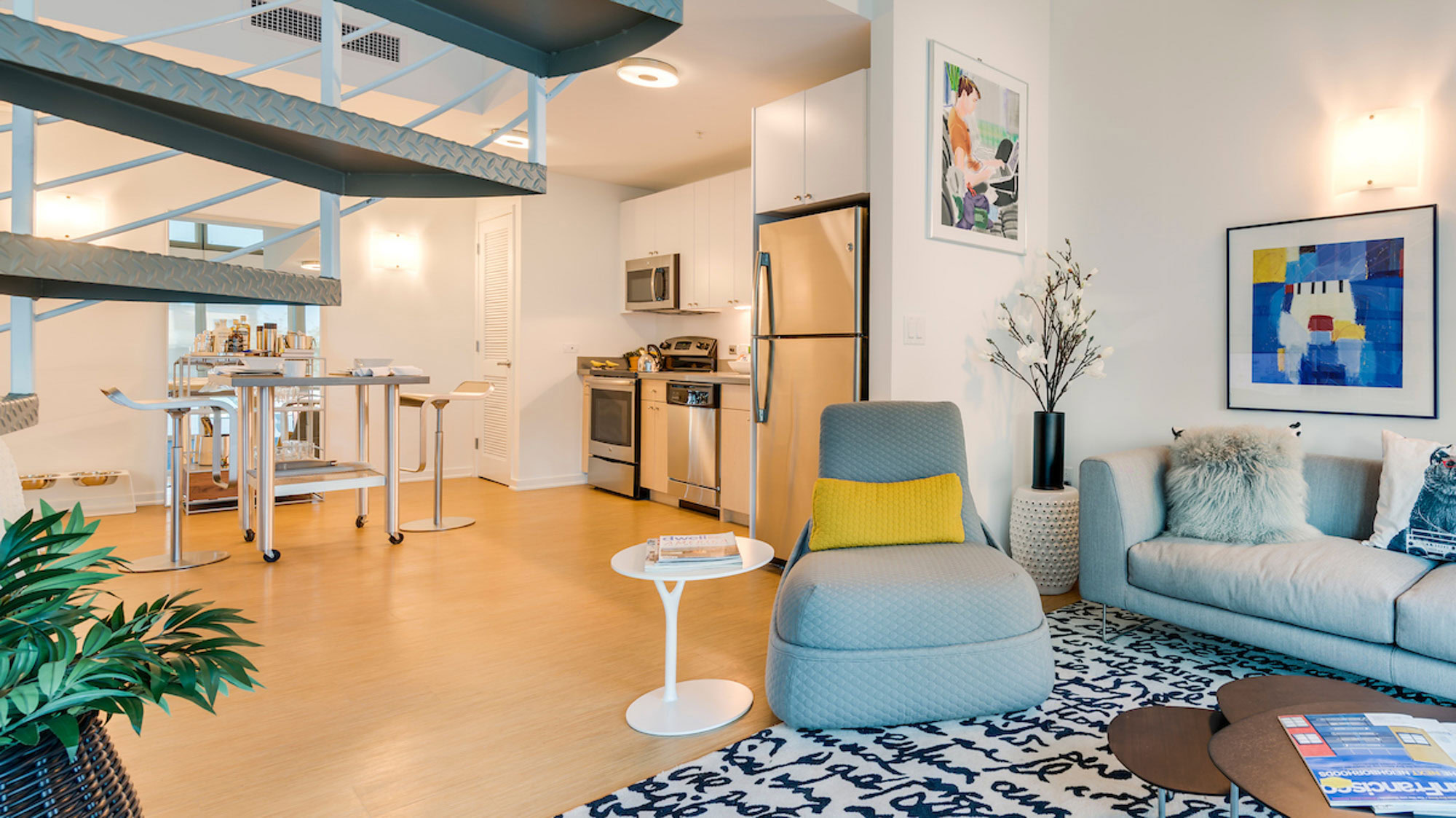 An open plan living kitchen and dining space leading to a living room at Mosso apartments in downtown San Francisco