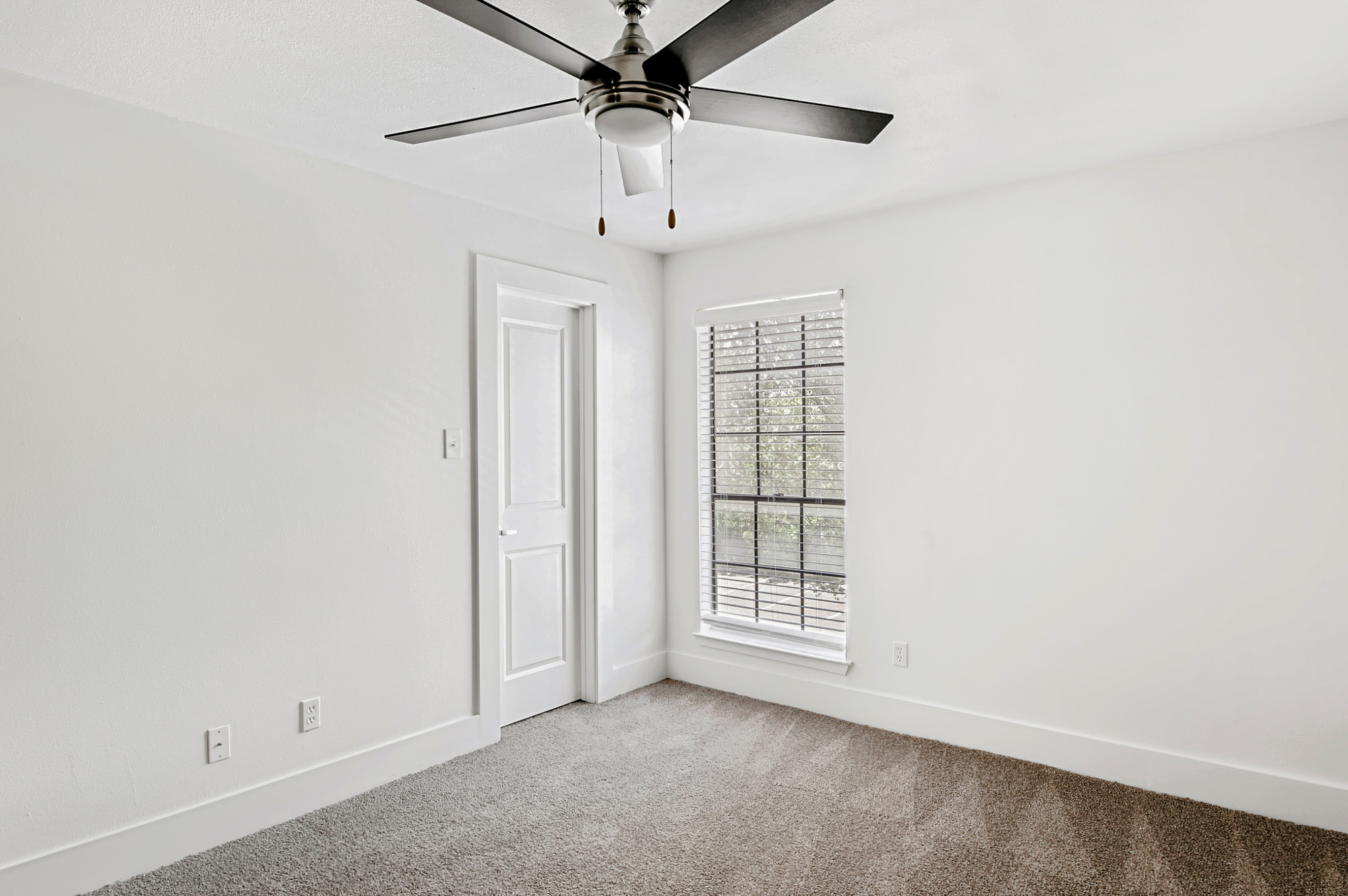 The bedroom of an apartment at The Arbors of Wells Branch in Austin, TX.