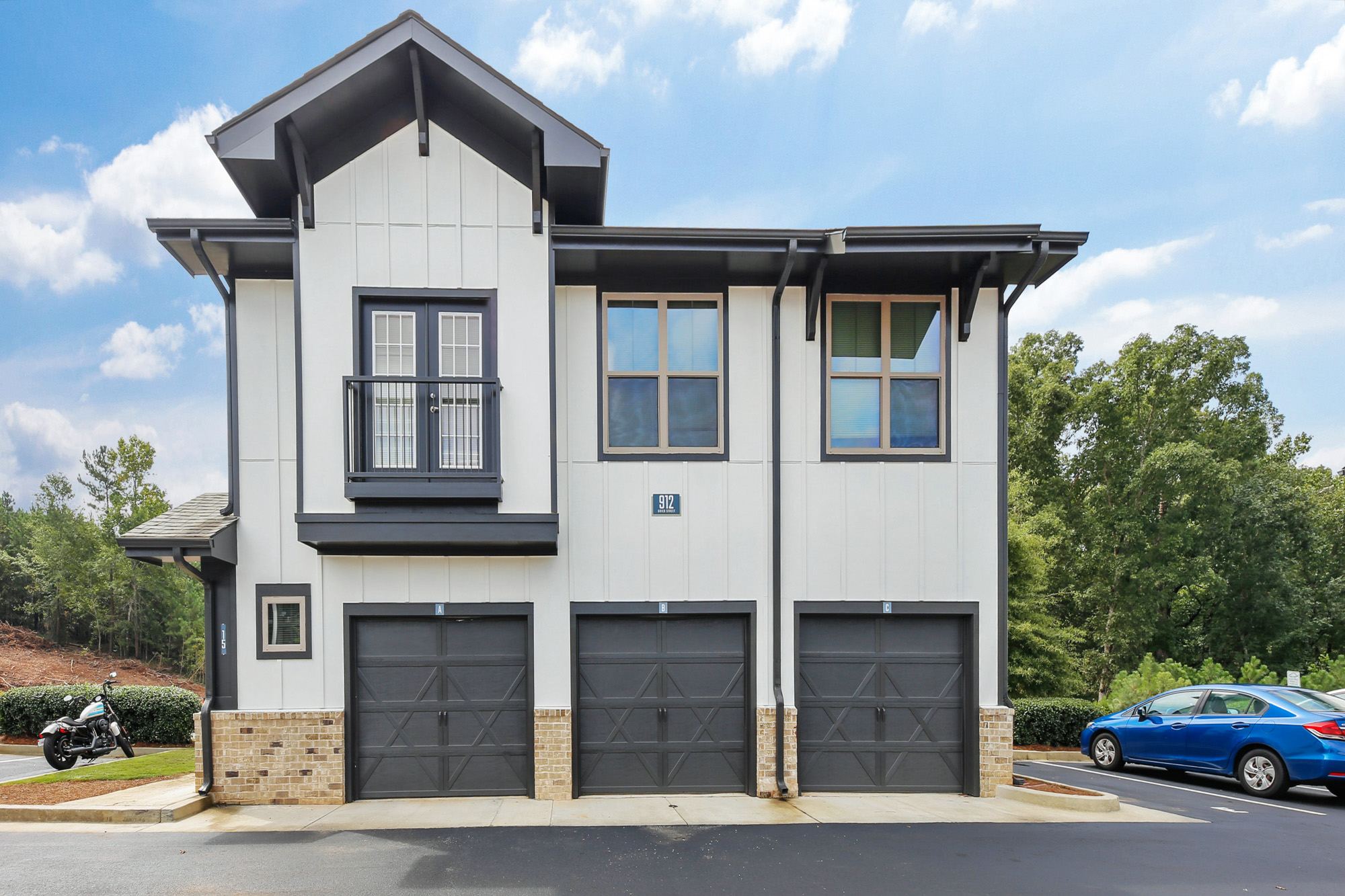 The back of an apartment building at Park 9 in Woodstock, GA featuring three attached garages.