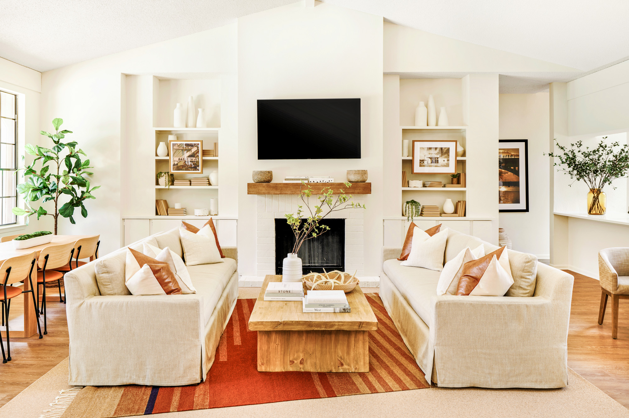 Two couches in front of a fireplace and mounted tv in the clubhouse at The Arbors at Wells Branch in Austin, TX.