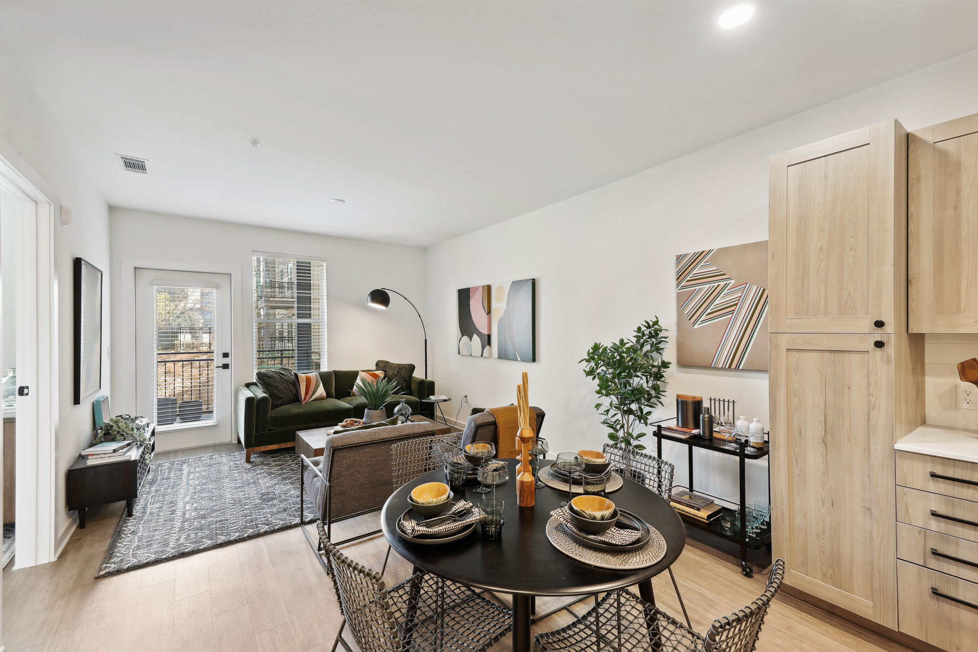 A dining area and living room in an open plan kitchen in a Tallulah apartment in Cumberland, GA