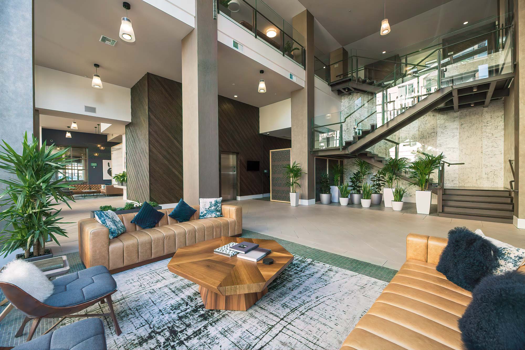 Lobby chairs and couches in front of elevators and stairs at The Village Residences luxury apartments in Mountain View, CA