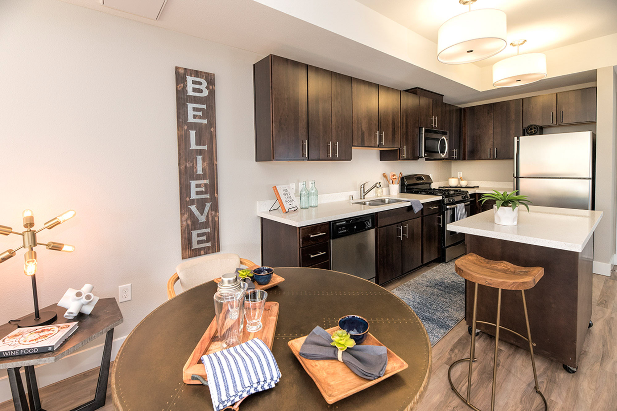 A kitchen and dining area featuring stainless steel appliances and a movable island at The Village Residences new apartments in Mountain View, CA