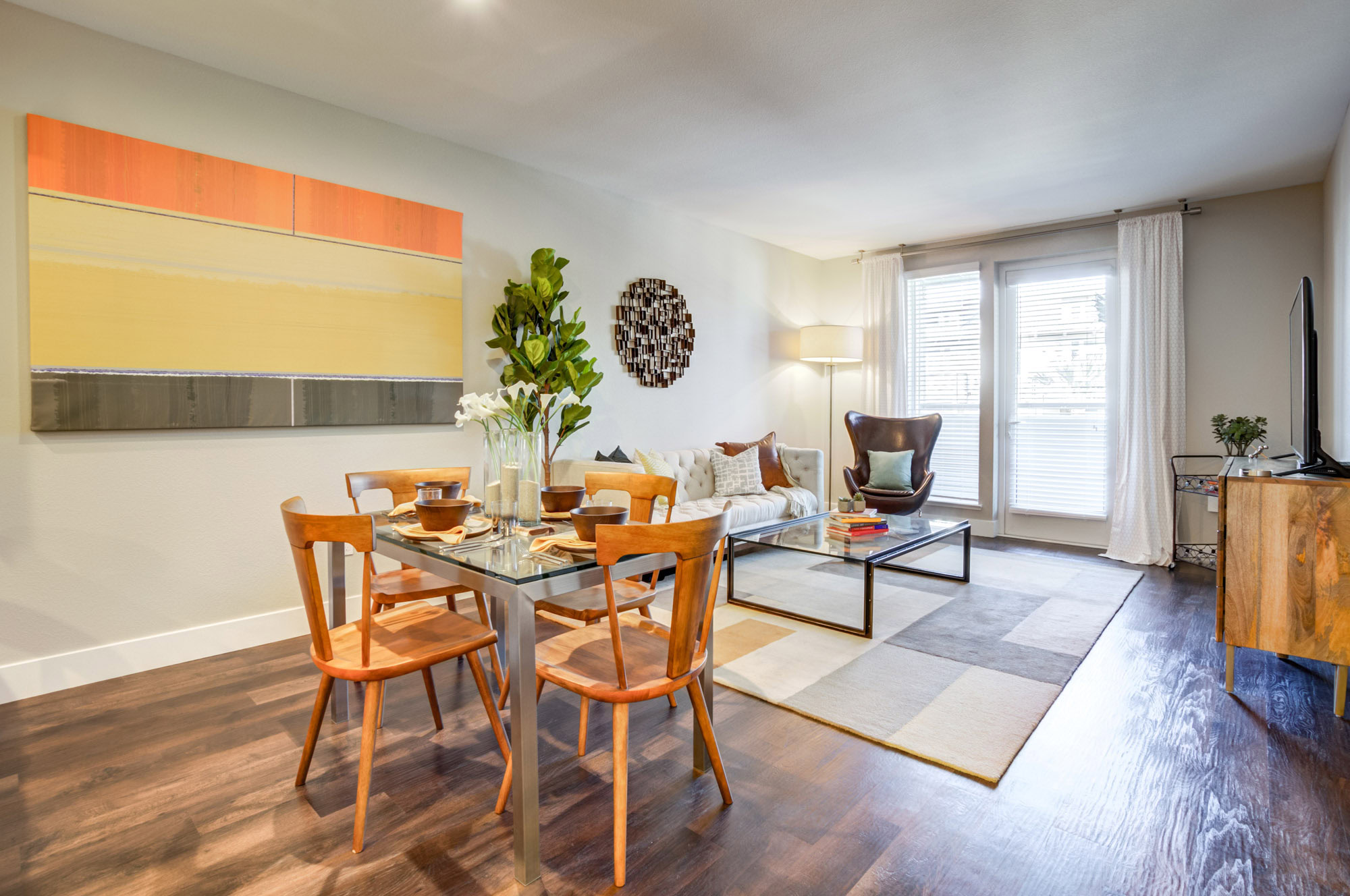 A dining room and living room with glass sliding doors to a balcony in an apartment at Vintage apartments in Pleasanton, CA