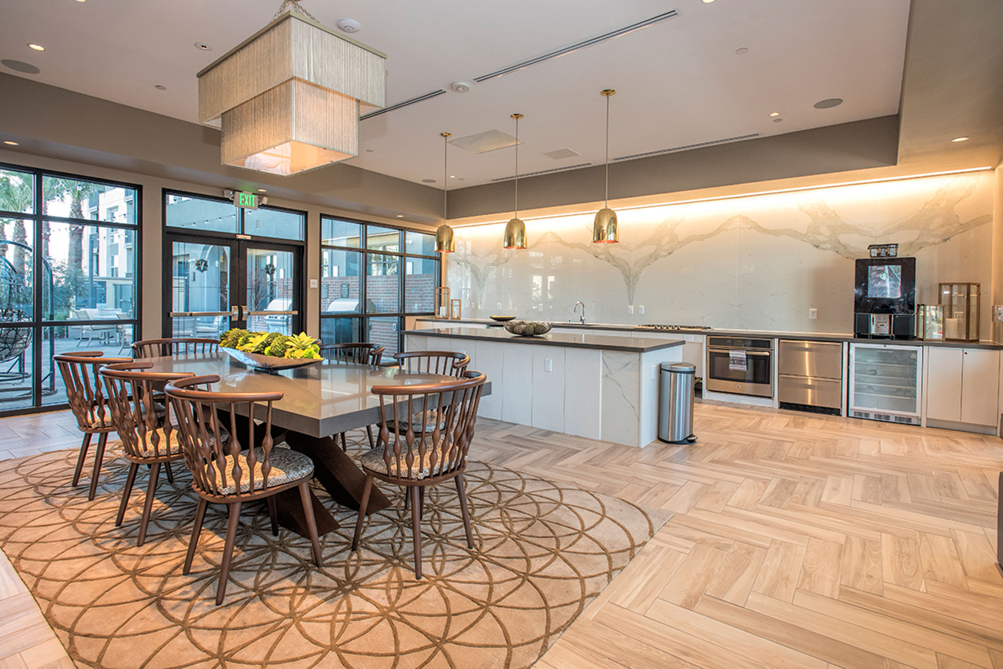 A catering open plan kitchen with an island behind a dining table for 8 at the Vintage apartments in Pleasanton, CA