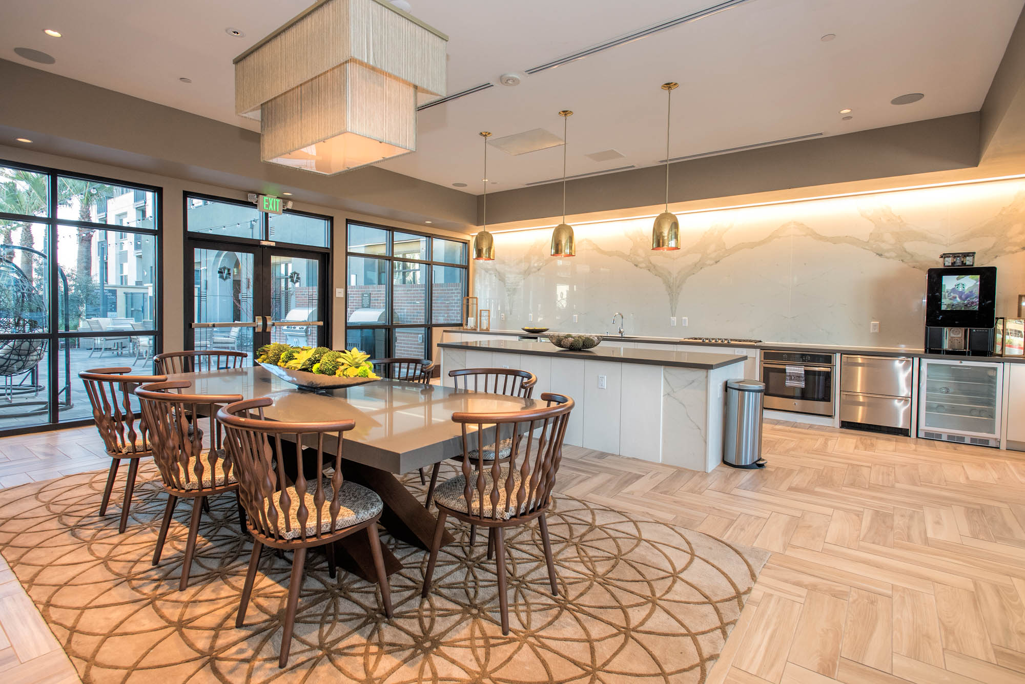A catering open plan kitchen with an island behind a dining table for 8 at the Vintage apartments in Pleasanton, CA